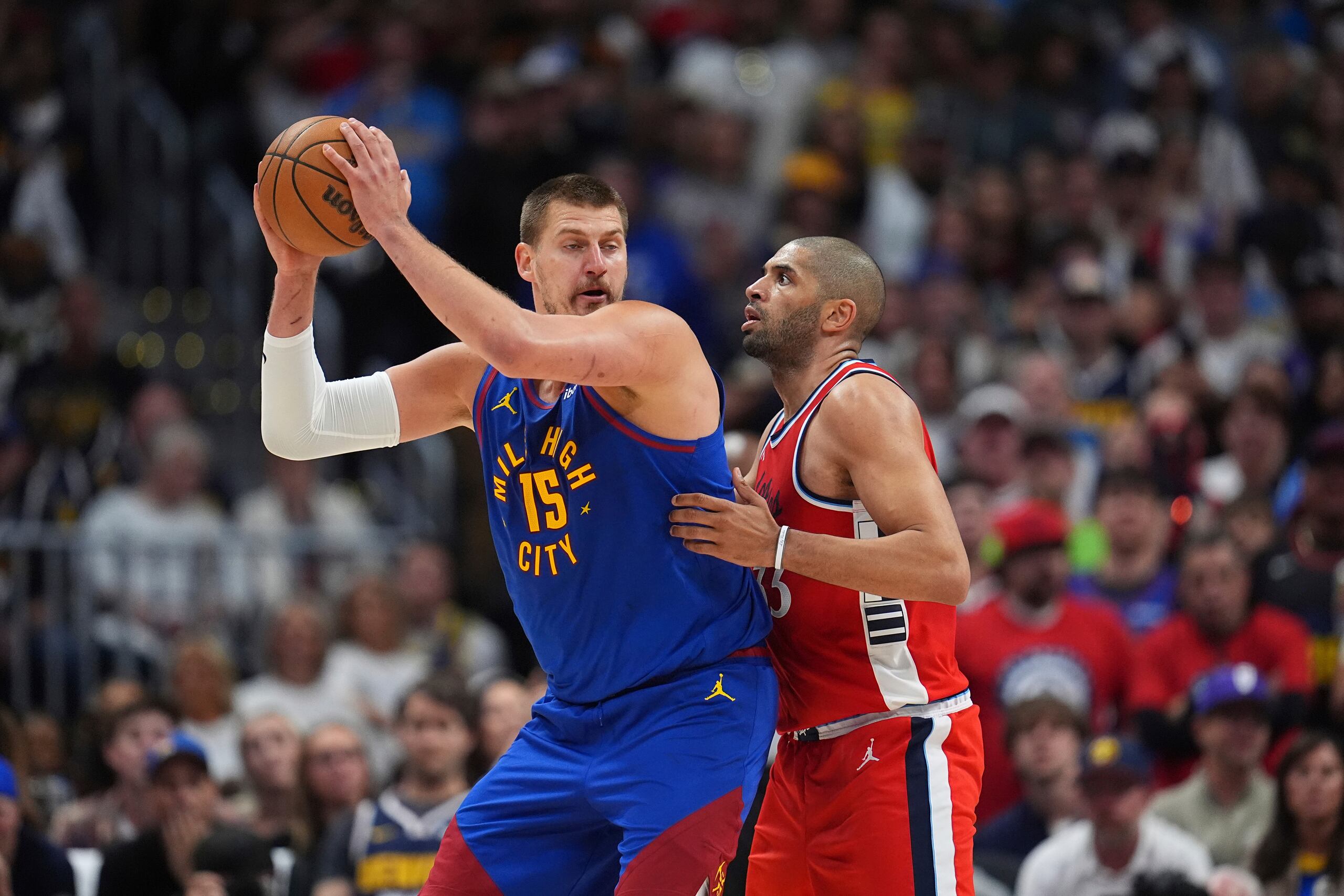 Denver Nuggets busca a un compañero para pasar un balón. Le defiende Nicolas Batum, de los Clippers.
