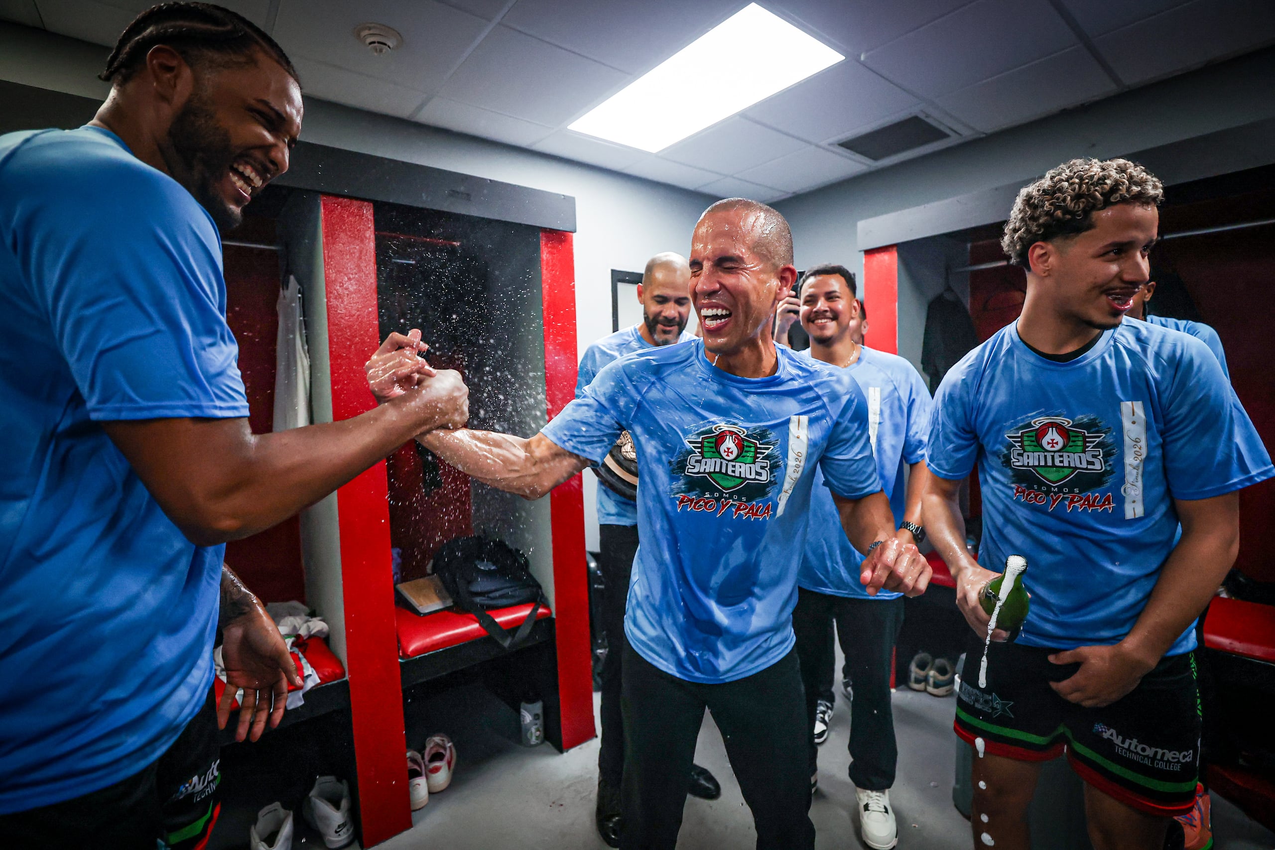 Rafael "Pachy" Cruz celebra el pase a la final del BSN de los Santeros de Aguada junto a Joel Soriano en el camerino visitante del Auditorio Juan "Pachín" Vicens.