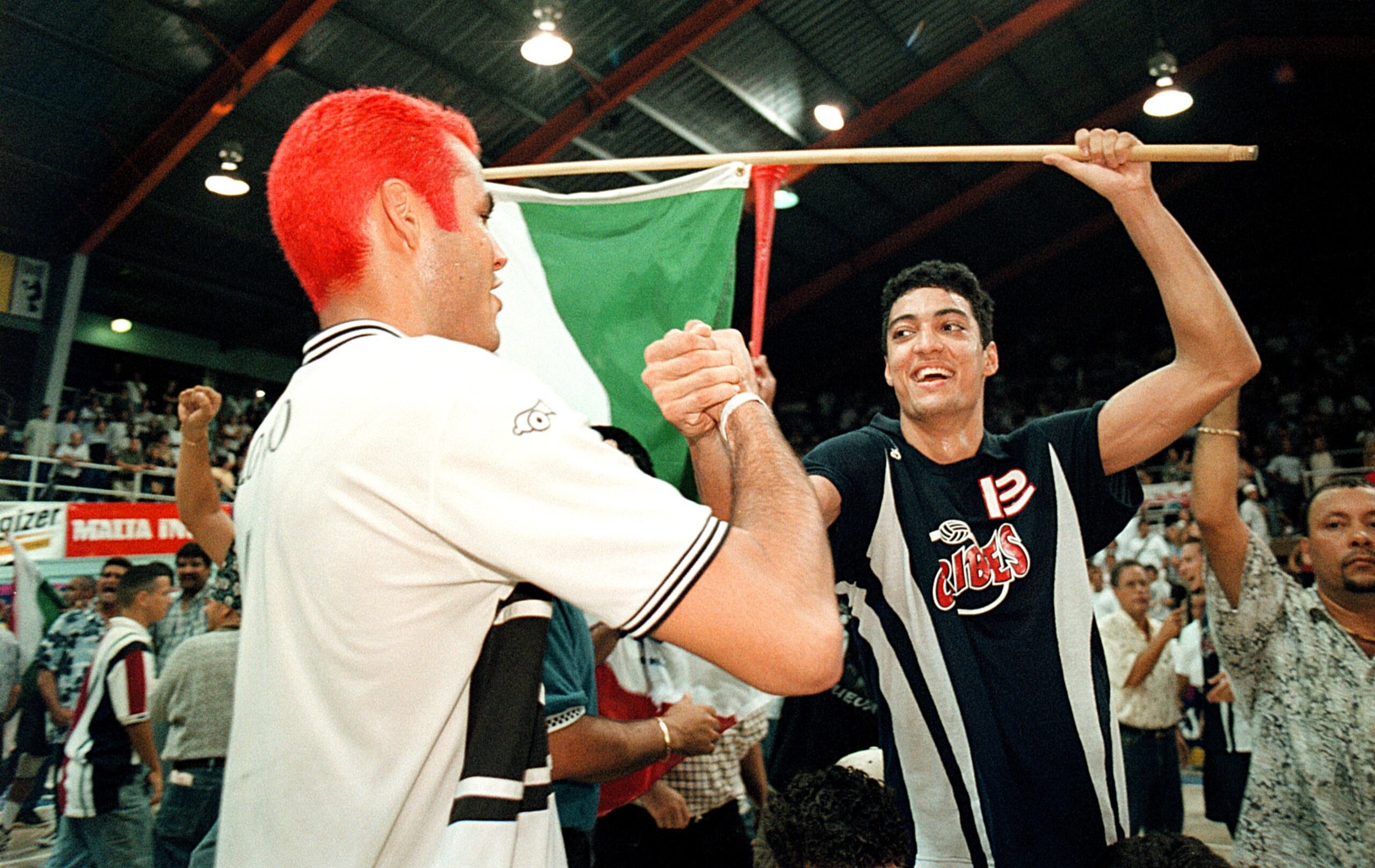 Momento elegante en que Víctor 'Vitito' Rivera felicita a Héctor 'Picky' Soto con bandera de San Sebastián en la final del 1999 en la cancha Pepín Cestero.