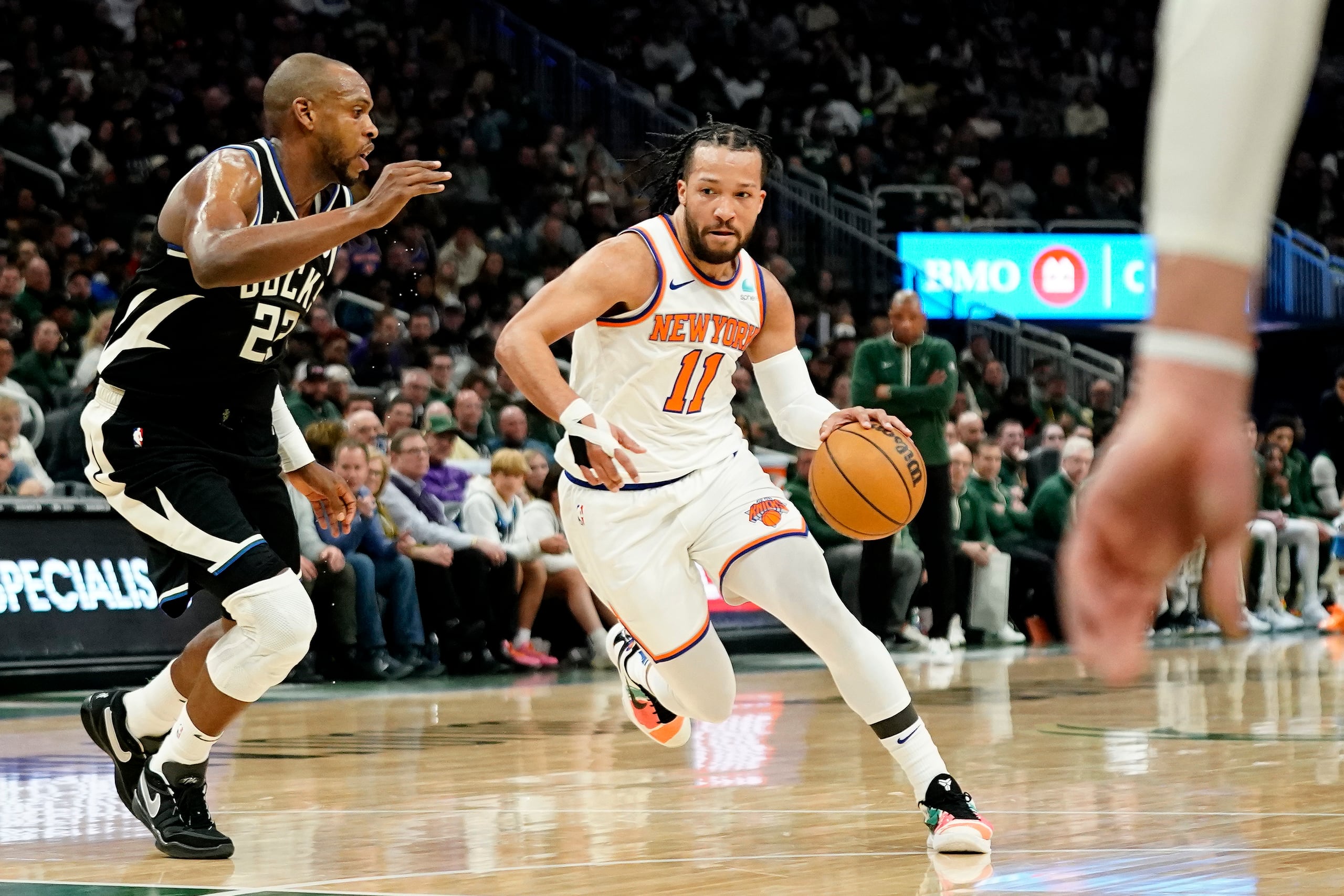 Jalen Brunson (11), de los Knicks de Nueva York, lleva el balón a la canasta, ante Khris Middleton, izquierda, de los Bucks de Milwaukee, durante la primera mitad del juego de baloncesto de la NBA, el domingo 7 de abril de 2024, en Milwaukee. (AP Foto/Aaron Gash)