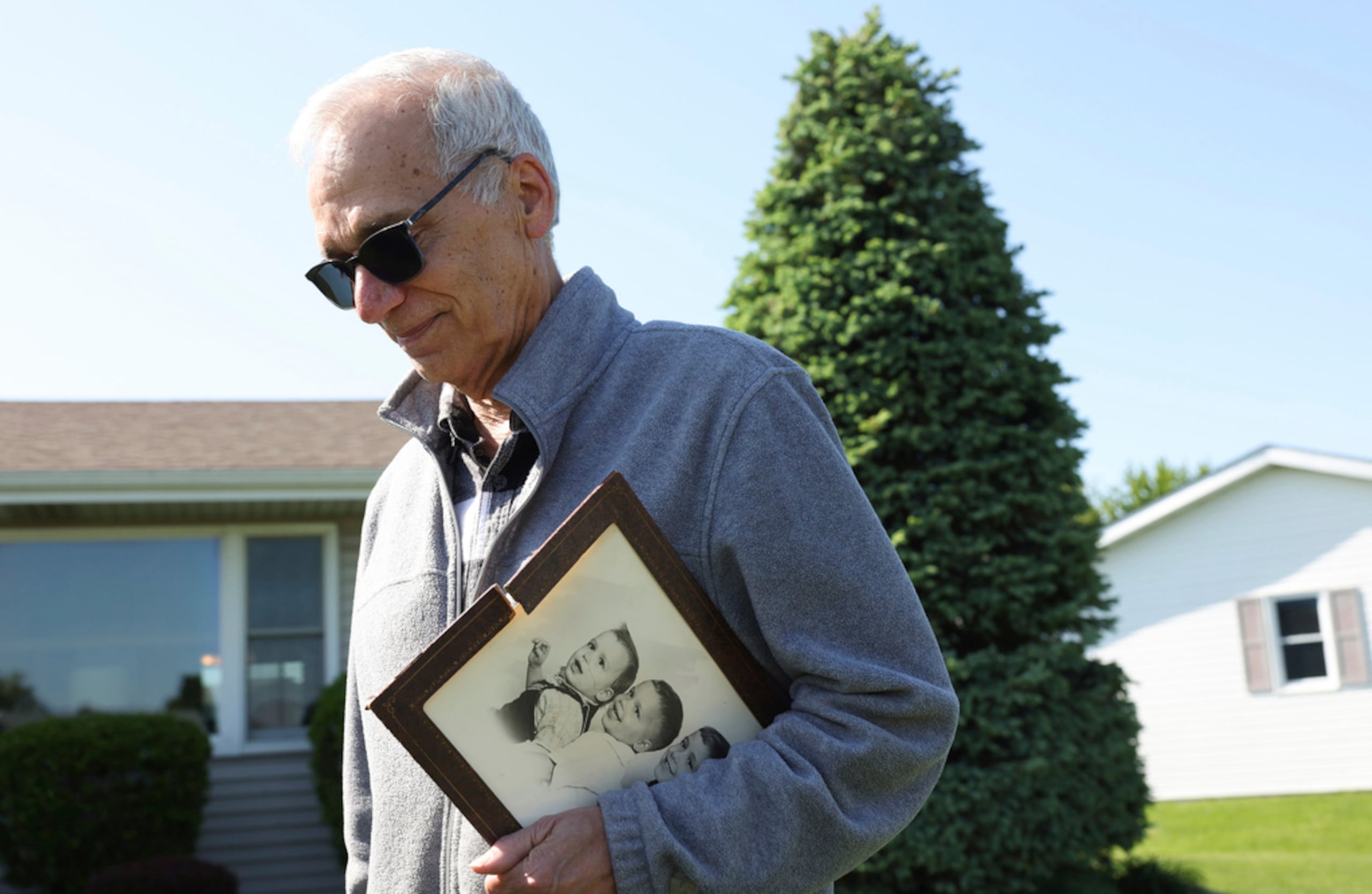 John Prevost, hermano del nuevo papa León XIV, sostiene un retrato de los tres hermanos Prevost de 1958 mientras responde preguntas de periodistas frente a su casa el 8 de mayo de 2025, en New Lenox, Illinois.