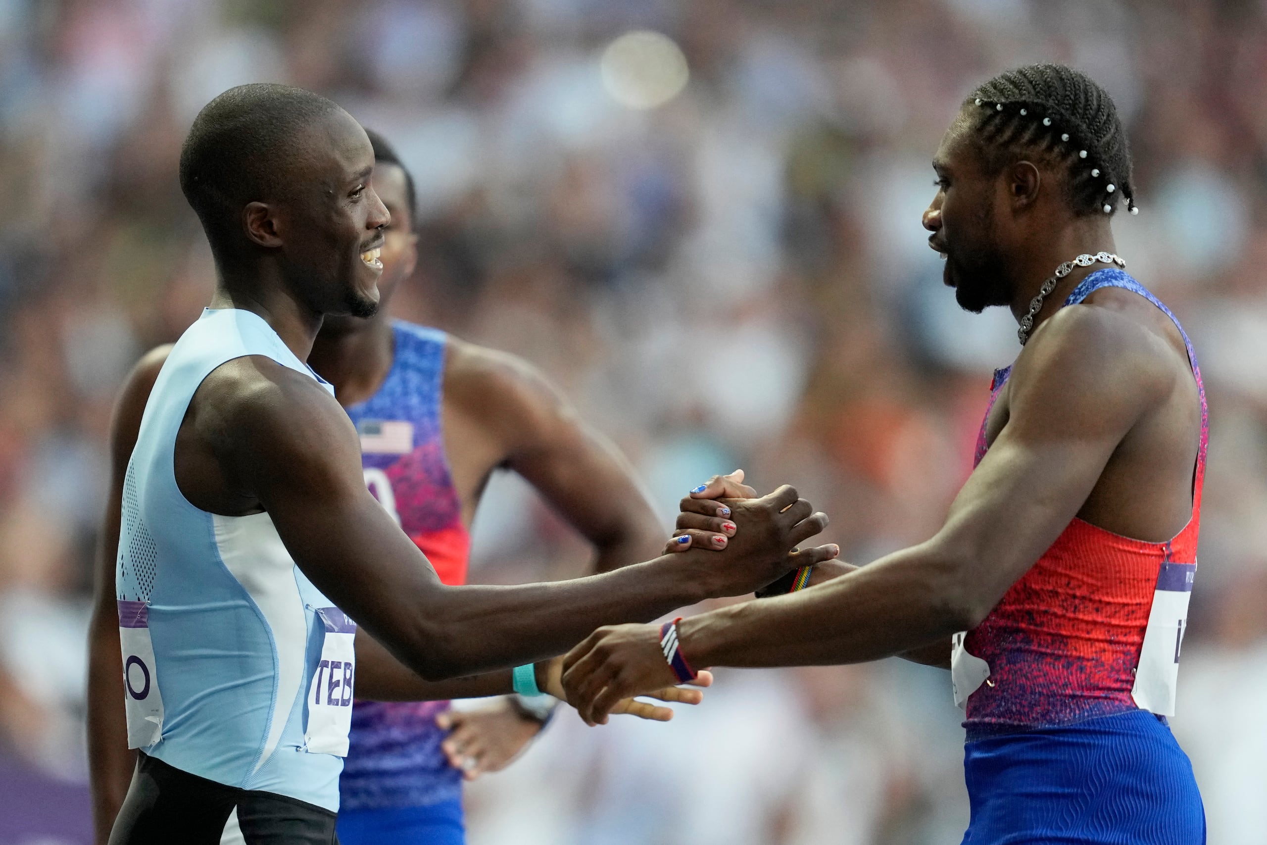 El ganador de la medalla de oro, Letsile Tebogo, de Botswana, y el ganador del bronce, Noah Lyles, se saludan tras la carrera.