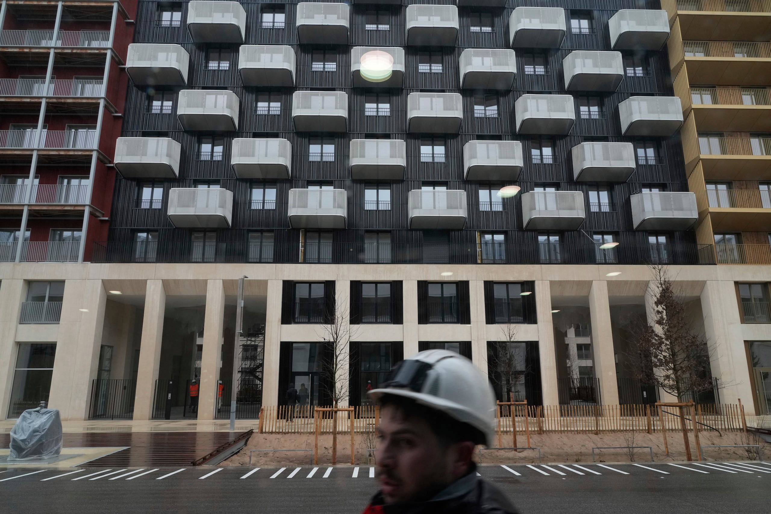 Un trabajador camina en una calle de la Villa Olímpica de Saint-Denis, el miércoles 28 de febrero de 2024.