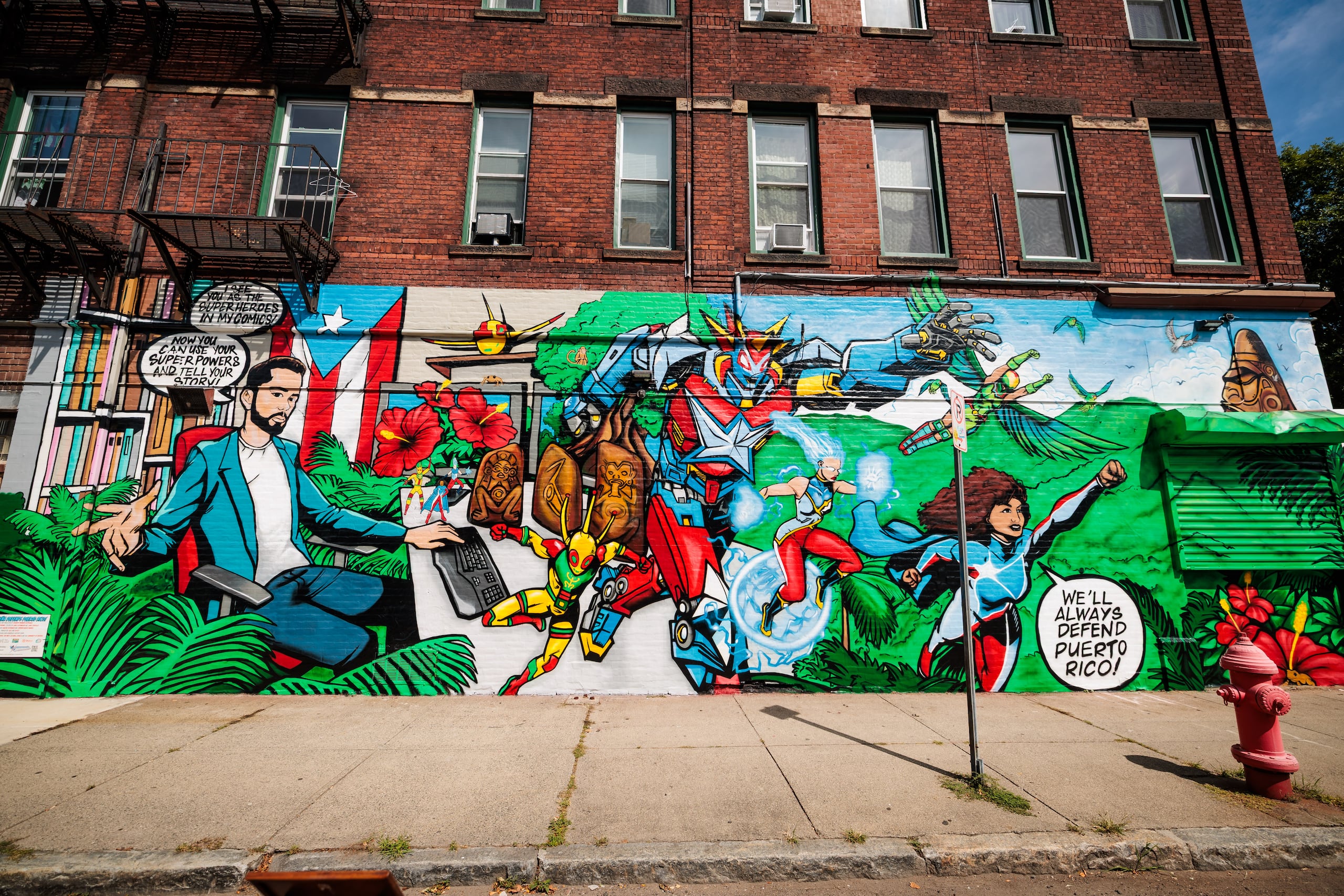 Fotografía cedida por Barr Foundation donde se aprecia el mural "La Borinqueña defiende Puerto Rico", obra de Edgardo Miranda-Rodriguez (retratado a la izquierda), pintado en una pared ubicada en la intersección de las calles Hamilton y Main en Holyoke, Massachusetts.