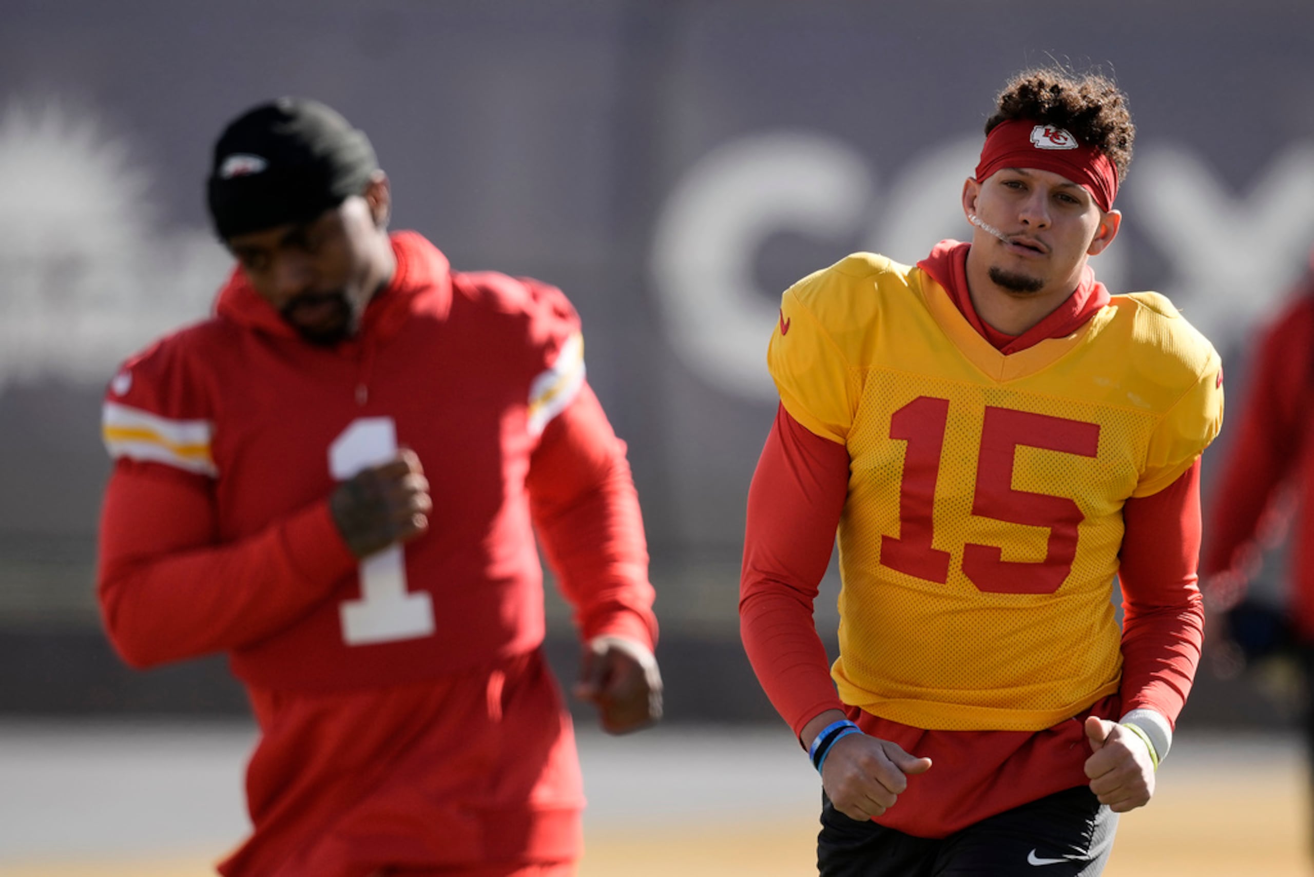El quarterback Patrick Mahomes (15) y el running back Jerick McKinnon (1) de los Chiefs de Kansas City durante un entrenamiento previo al Super Bowl.