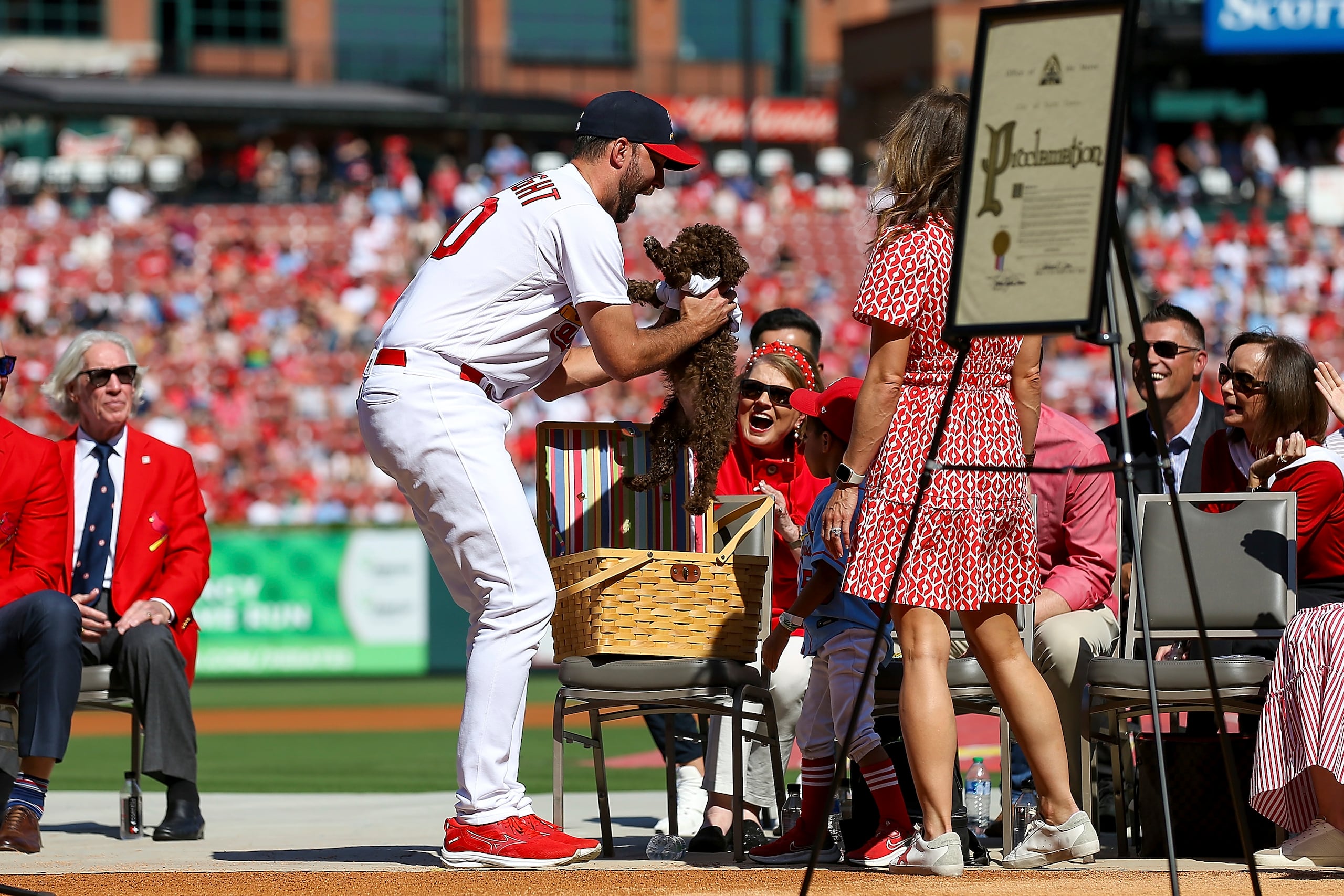 Adam Wainwright le entrega el cachorro a su hijo.