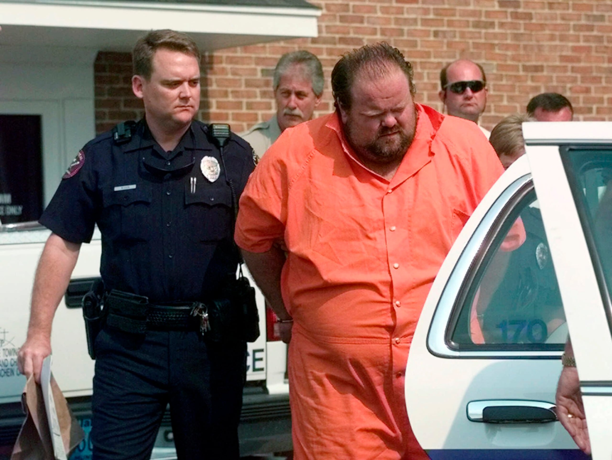 Agentes escoltan al sospechoso de homicidio Alan Eugene Miller el 5 de agosto de 1999 desde la prisión de Pelham en Alabama.