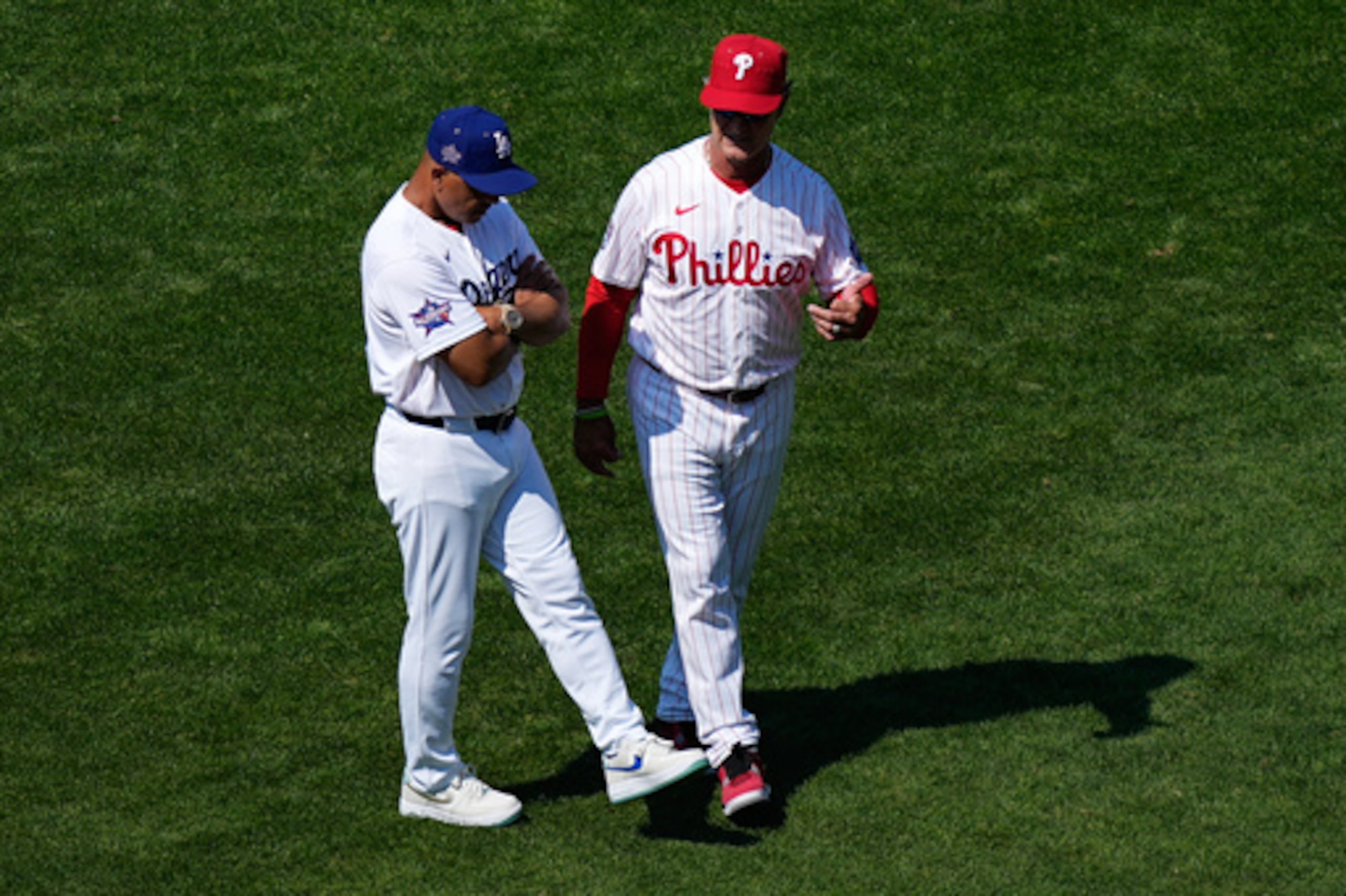 El dirigente interino de los Phillies de Filadelfia, Don Mattingly, a la derecha, y el piloto de los Dodgers de Los Ángeles, Dave Roberts.