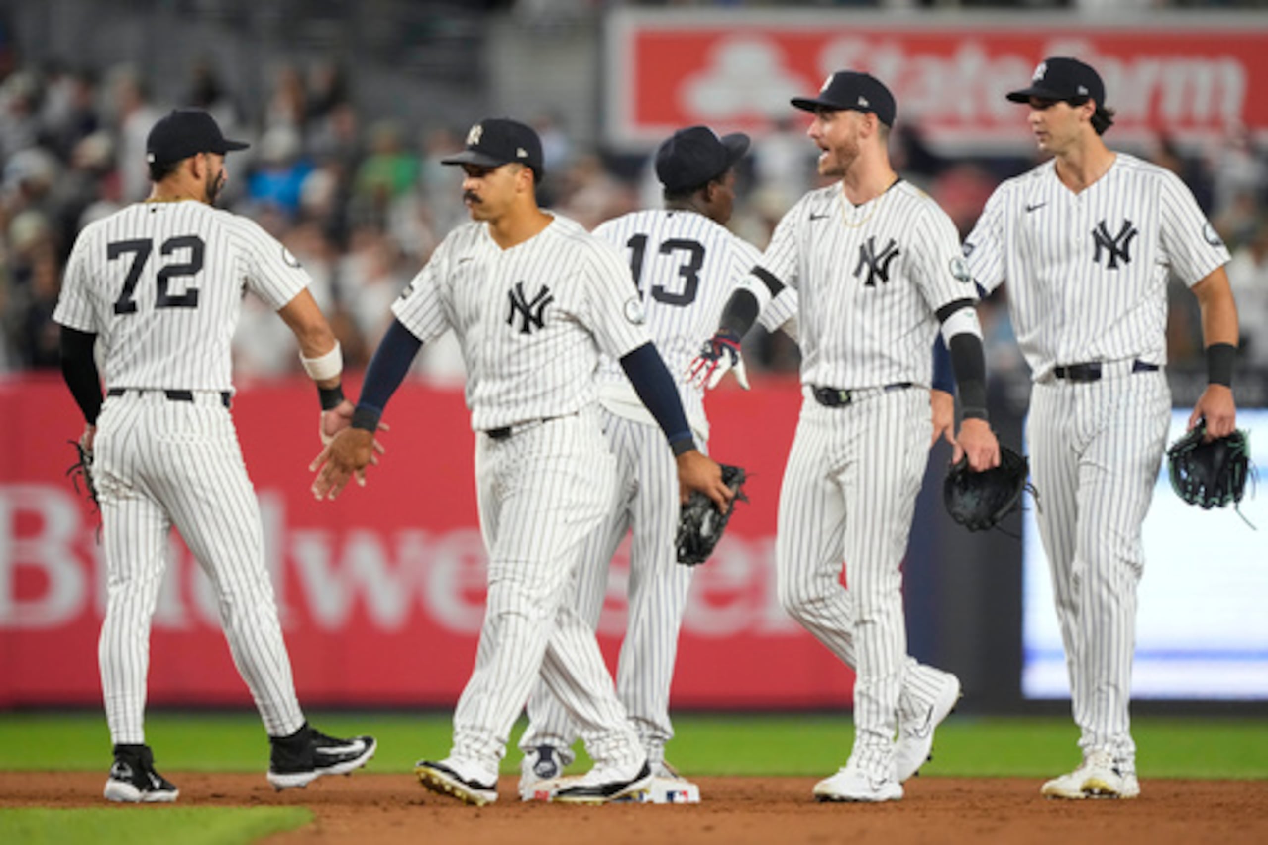 El jardinero derecho de los Yankees de Nueva York, Spencer Jones; el jardinero izquierdo, Cody Bellinger; y el jardinero central, Trent Grisham —de derecha a izquierda— celebran con sus compañeros de equipo tras ganar un partido de béisbol contra los Red Sox de Boston, el viernes 28 de agosto de 2026, en Nueva York. (Foto AP/Yuki Iwamura)