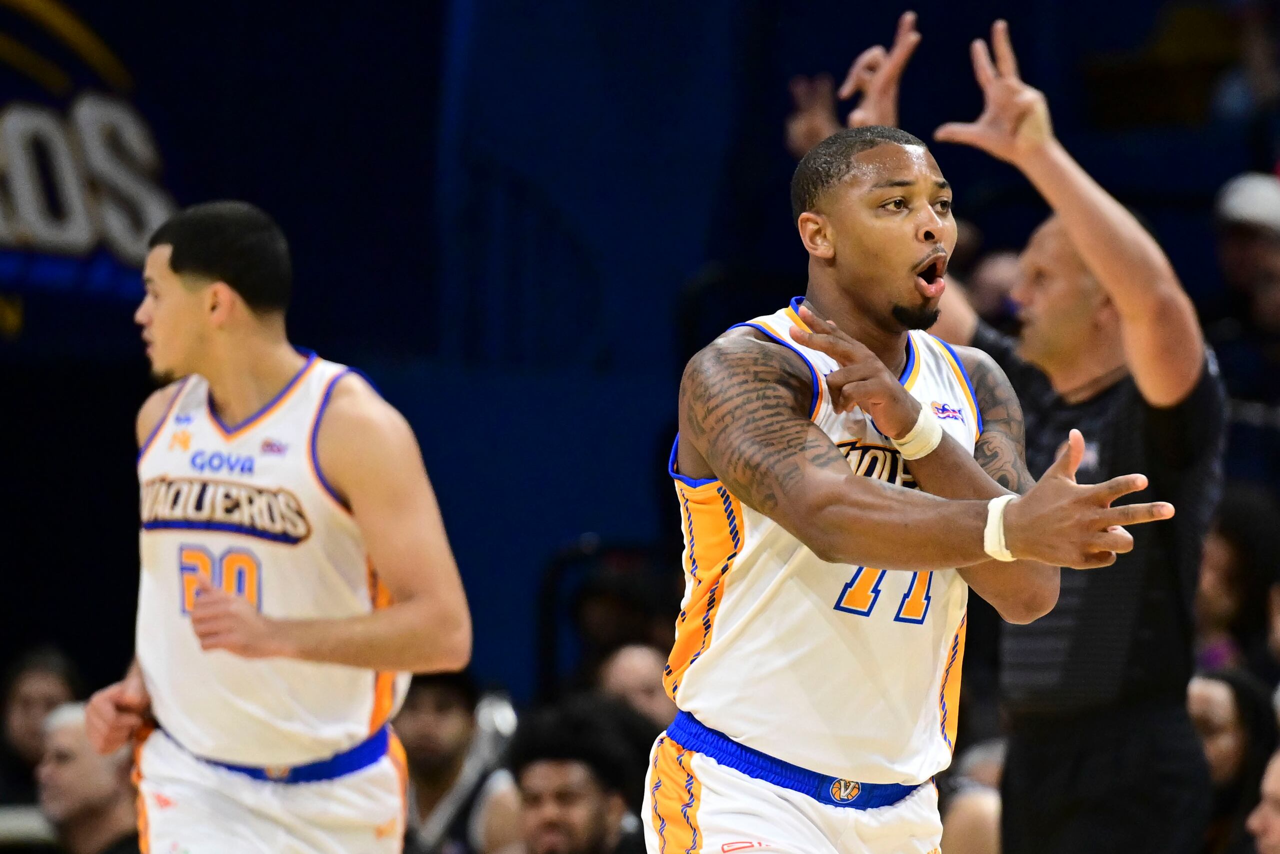 El nuevo refuerzo de los Vaqueros de Bauamón, Quentin Peterson, (derecha) festeja un triple ante los Gigantes de Carolina.