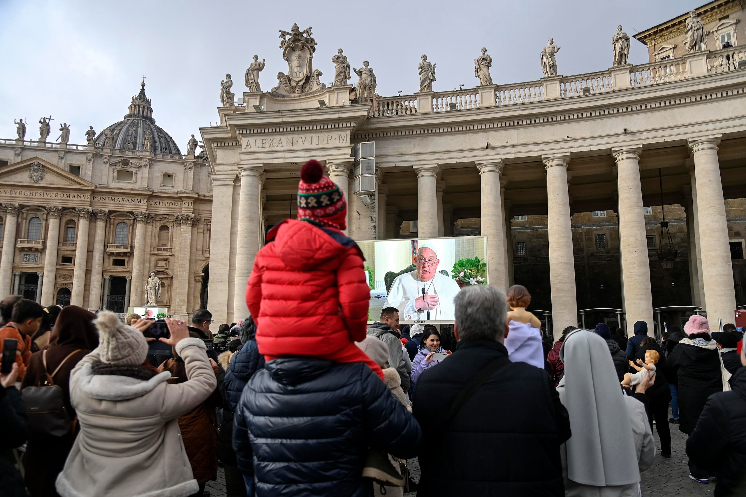 Feligreses siguen en la plaza de San Pedro el rezo del ángelus del papa Francisco.