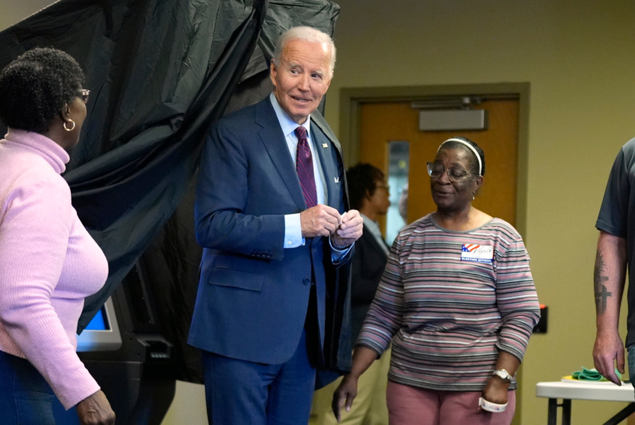 El presidente Joe Biden sostiene una calcomanía de "Voté anticipadamente" al salir de la cabina de votación después de emitir su voto para las elecciones generales de 2024, el 28 de octubre de 2024, en New Castle, Delaware.
