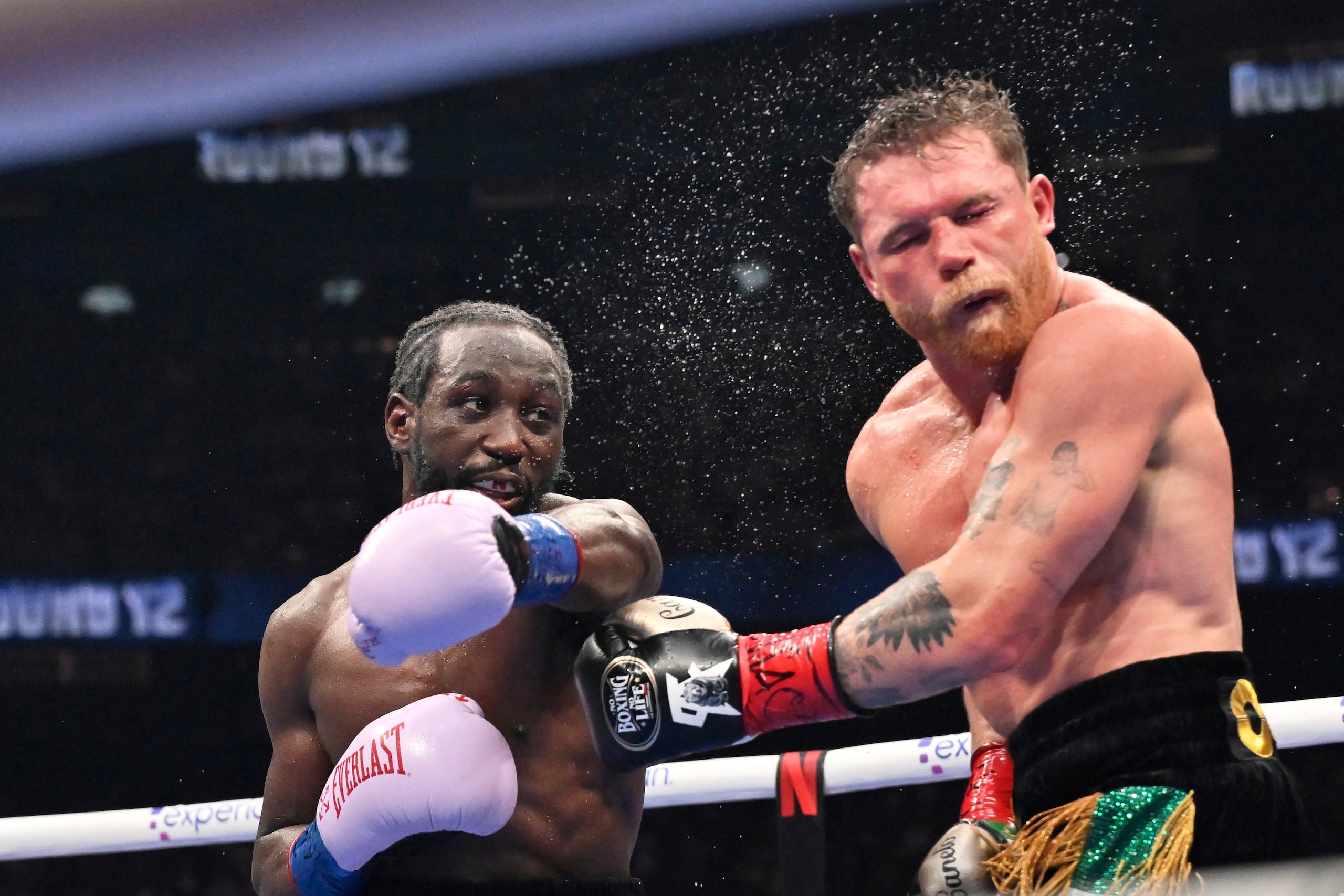 Terence Crawford, izquierda, conecta un golpe a Canelo Álvarez durante su pelea de campeonato indiscutido del peso supermedio en Las Vegas.