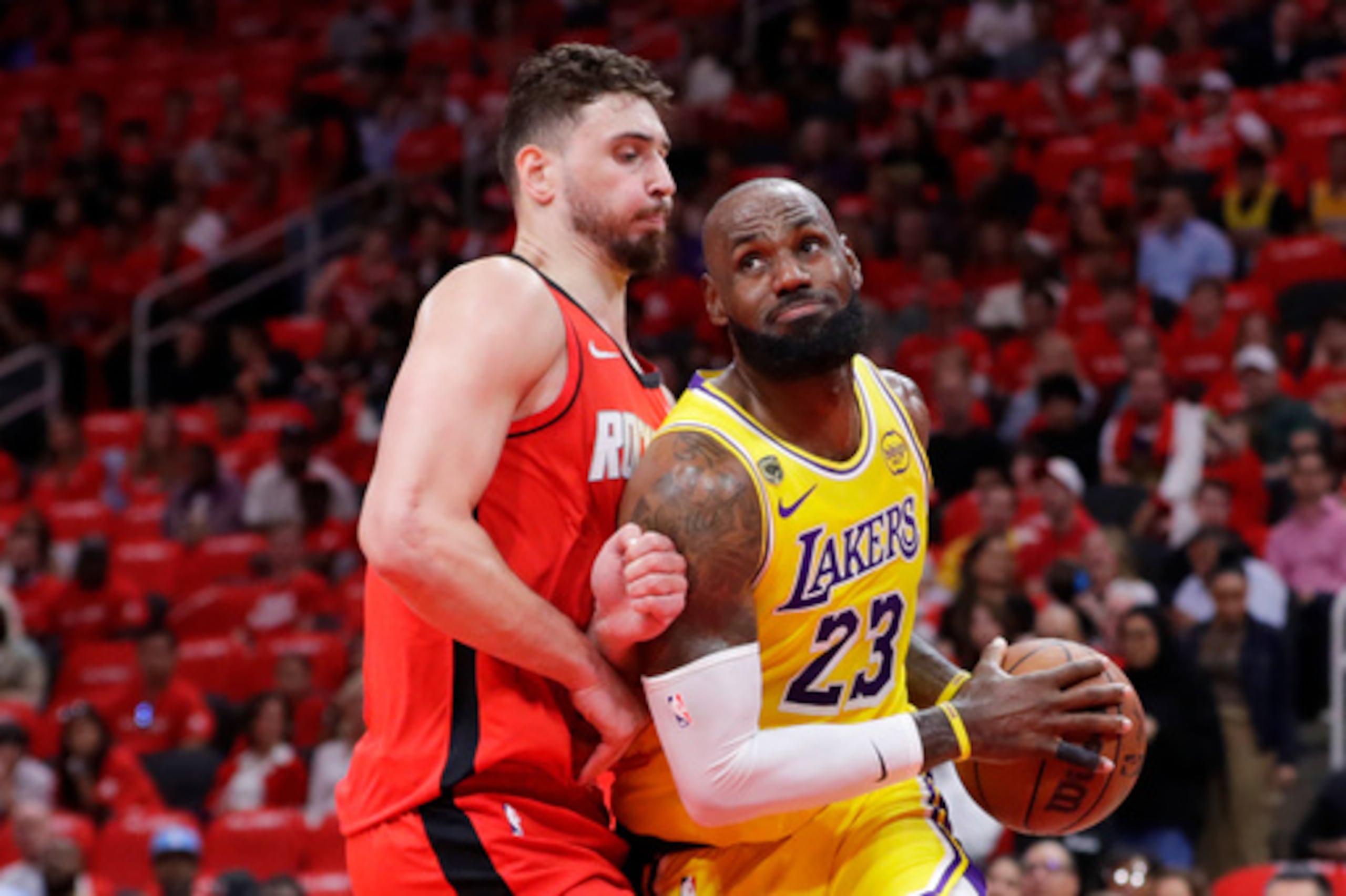 El alero de los Lakers de Los Ángeles LeBron James (23) conduce hacia la canasta frente al pívot de los Rockets de Houston Alperen Sengun, izquierda, durante la primera mitad del tercer partido de la primera ronda de los playoffs de baloncesto de la NBA el viernes 24 de abril de 2026, en Houston. (AP Photo/Michael Wyke)