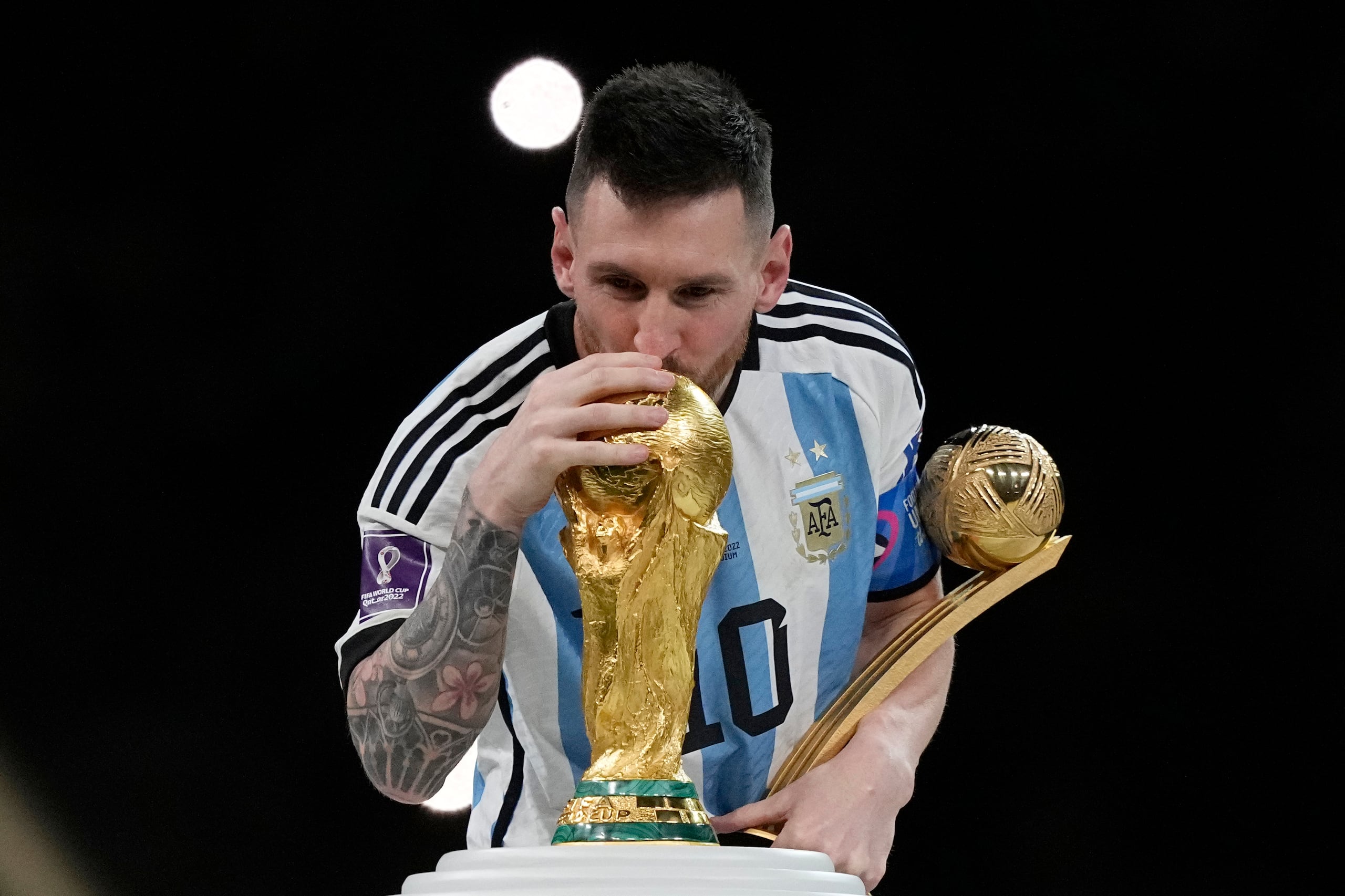 El astro argentino Lionel Messi besa el trofeo del Mundial tras ganar la final contra Francia en 2022.