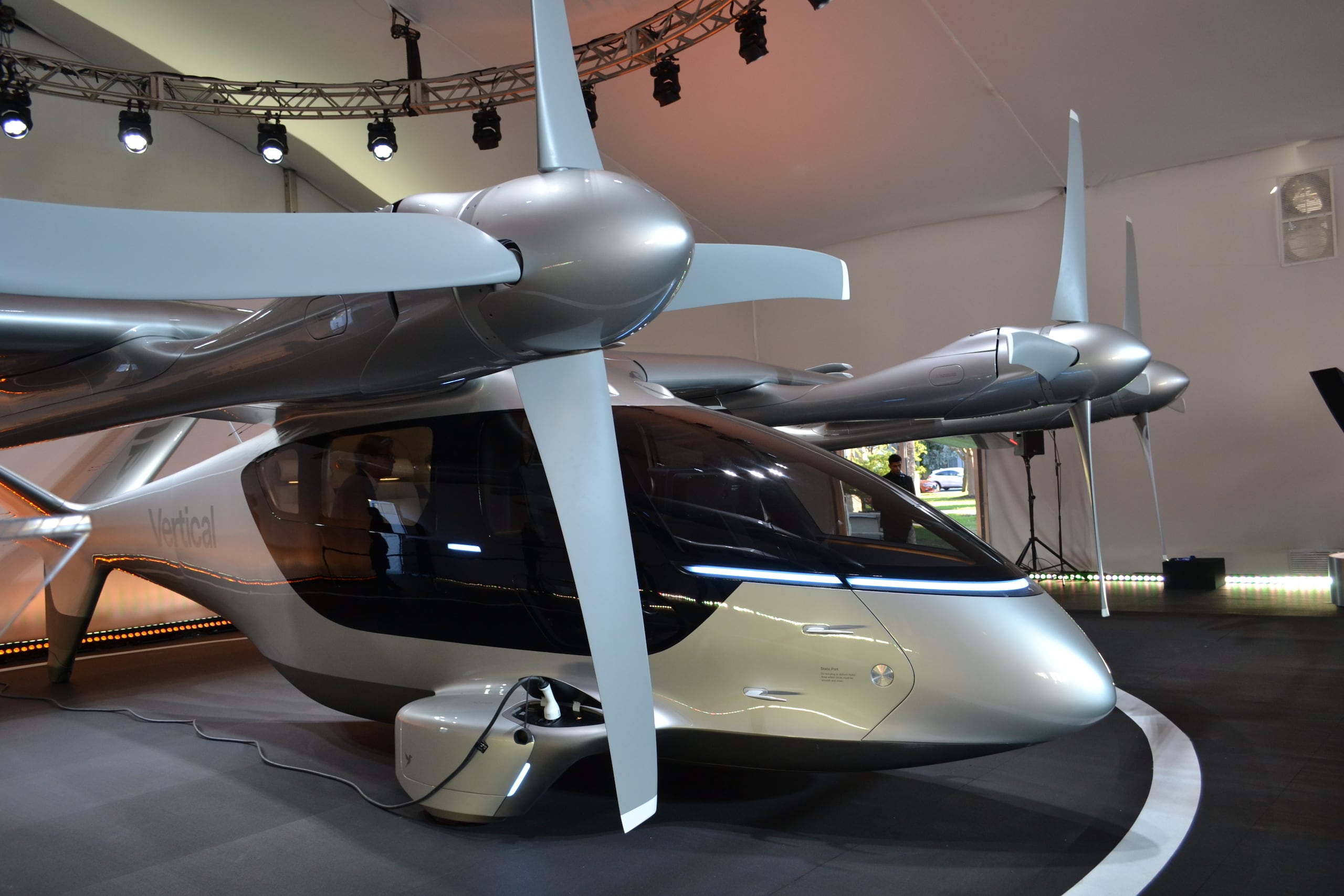 Unas personas observan a un taxi volador eléctrico de la compañía Vertical Aerospace expuesto el 24 de febrero de 2026, en Miami Beach, Florida. Miami. (EFE/Antoni Belchi)
