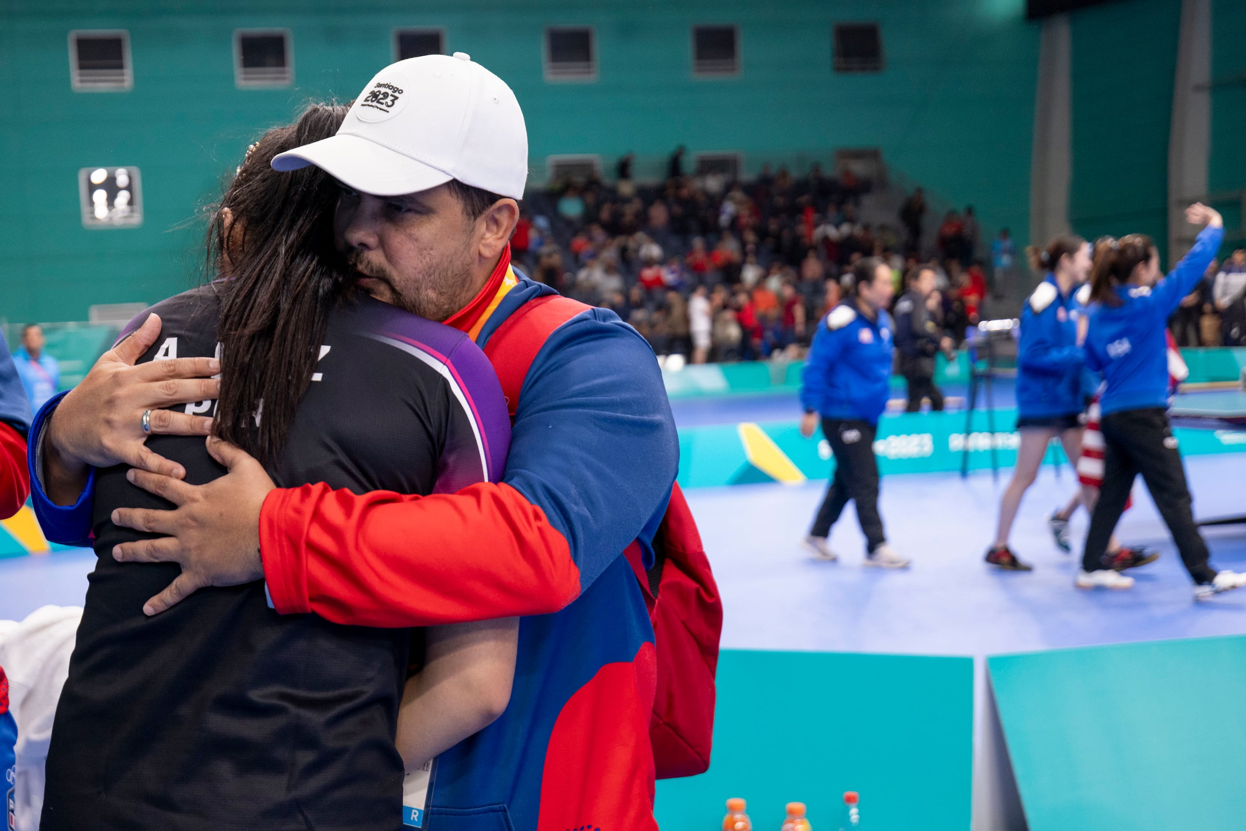 El entrenador Bladimir Díaz consuela a Adriana Díaz al finalizar el partido final.