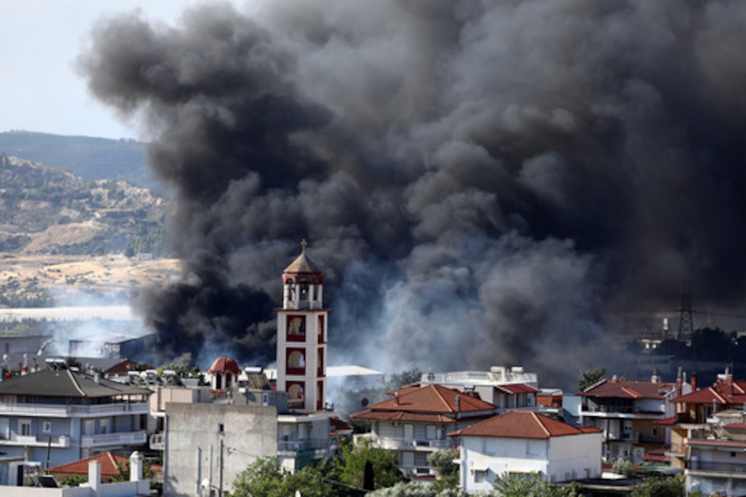 Un denso humo se eleva sobre el asentamiento de Filothei durante un incendio forestal en las afueras de la ciudad de Tesalónica, al norte de Grecia, el domingo 5 de julio de 2026. (Foto AP/Giannis Papanikos)