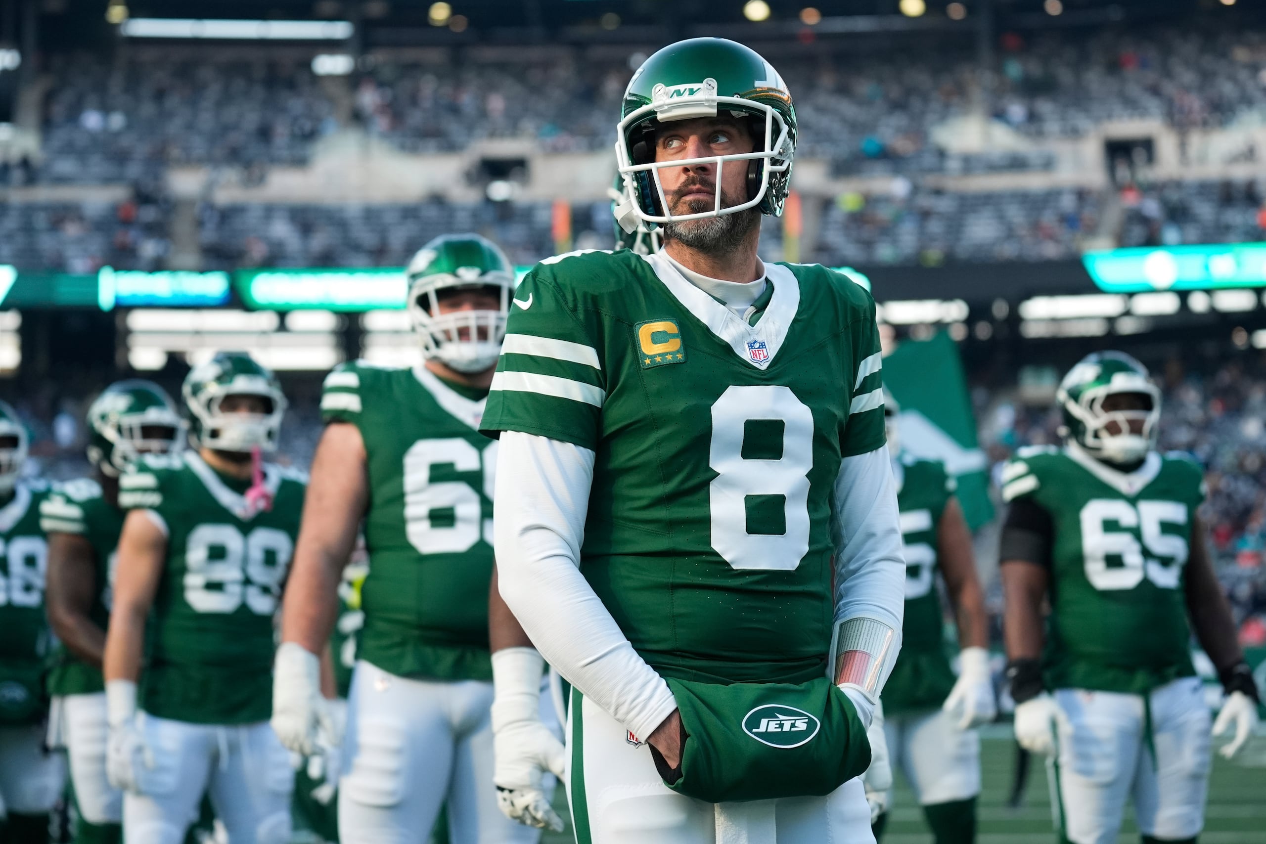 El quarterback Aaron Rodgers (8), de los Jets de Nueva York, está parado junto a sus compañeros de equipo previo a un partido en contra de los Dolphins de Miami, el 5 de enero de 2025, en East Rutherford, Nueva Jersey.