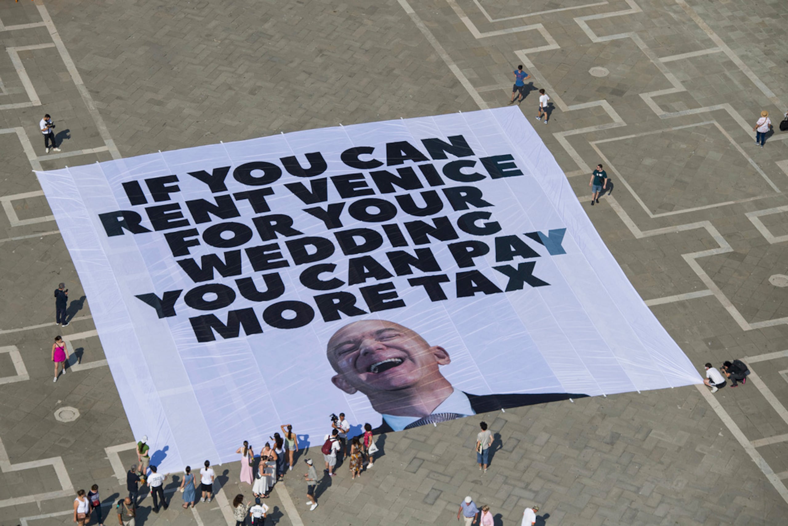 Esta foto difundida por Greenpeace muestra una gran pancarta en contra de la boda planeada del fundador de Amazon, Jeff Bezos, en la Plaza de San Marcos, en Venecia, Italia, el 23 de junio de 2025.
