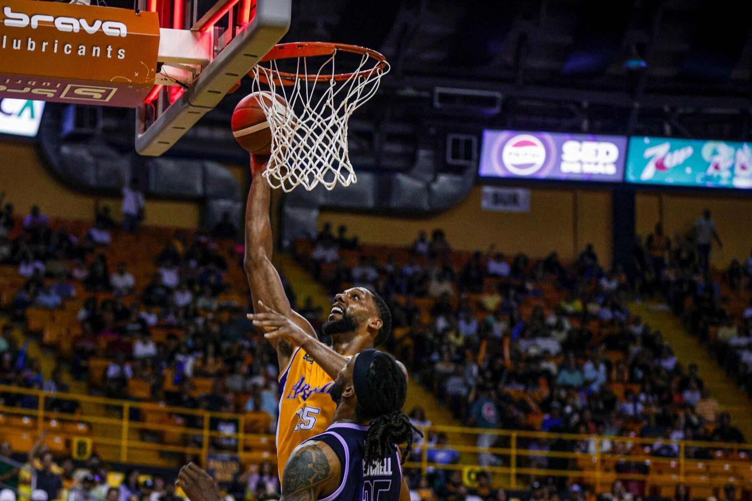 Jahlil Okafor, de los Capitanes de Arecibo, lanza al canasto ante Akil Mitchell, de los Criollos de Caguas.