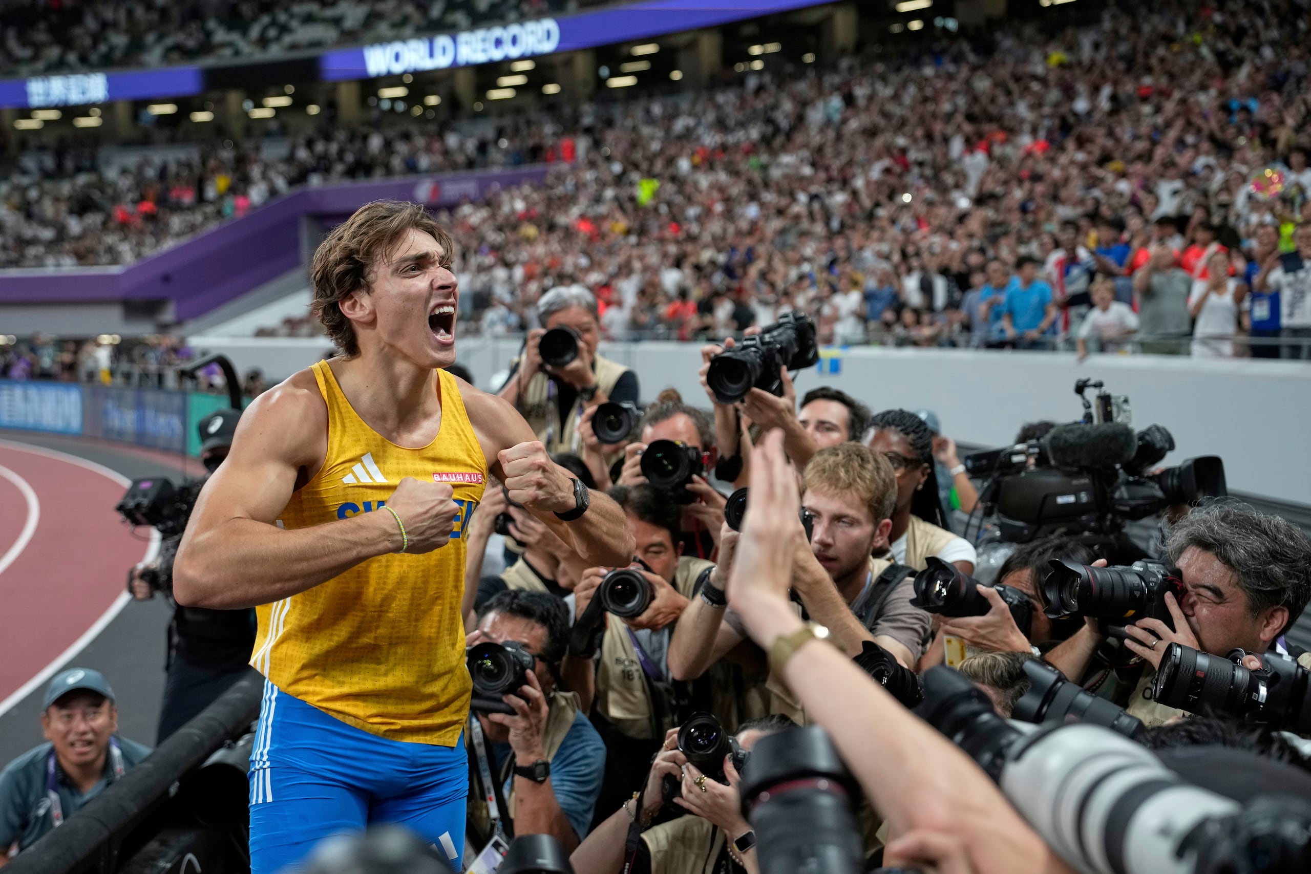 Armand Duplantis celebra tras romper el récord mundial del salto con pértiga del Mundial de atletismo.