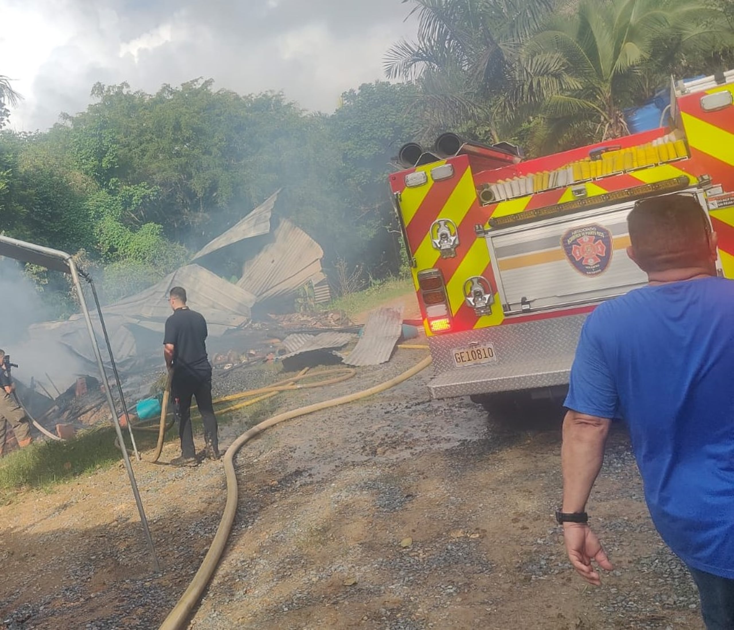 Bomberos combaten las llamas en el fuego desatado en la vivienda de madera y zinc.