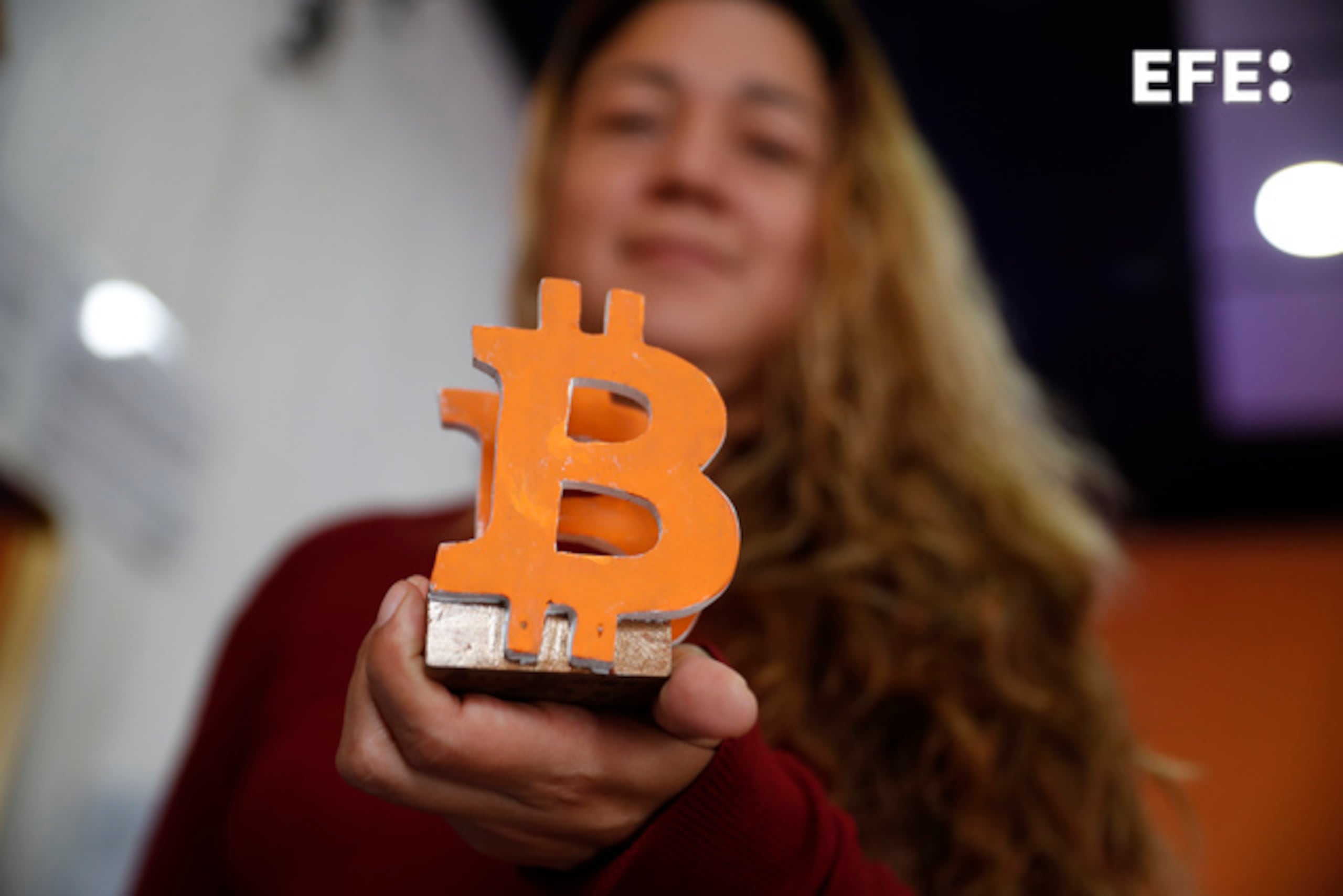 Patricia, facilitadora en el Centro Comunitario Botcóin, muestra un adorno con el logo del bitcóin, el 4 de septiembre de 2024, en Berlín, en El Salvador. (EFE/Rodrigo Sura)