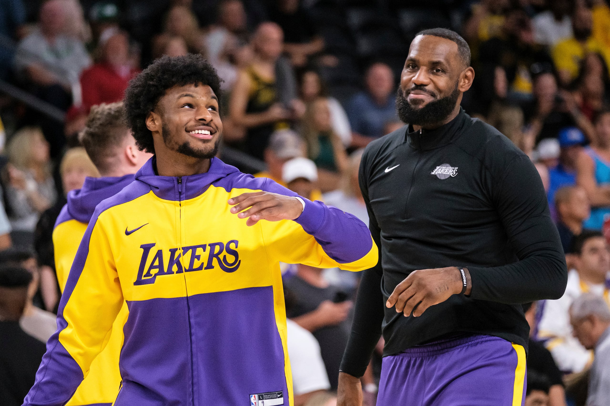 El base de los Lakers de Los Ángeles, Bronny James, y el alero LeBron James calientan antes de un encuentro de pretemporada ante los Suns de Phoenix.