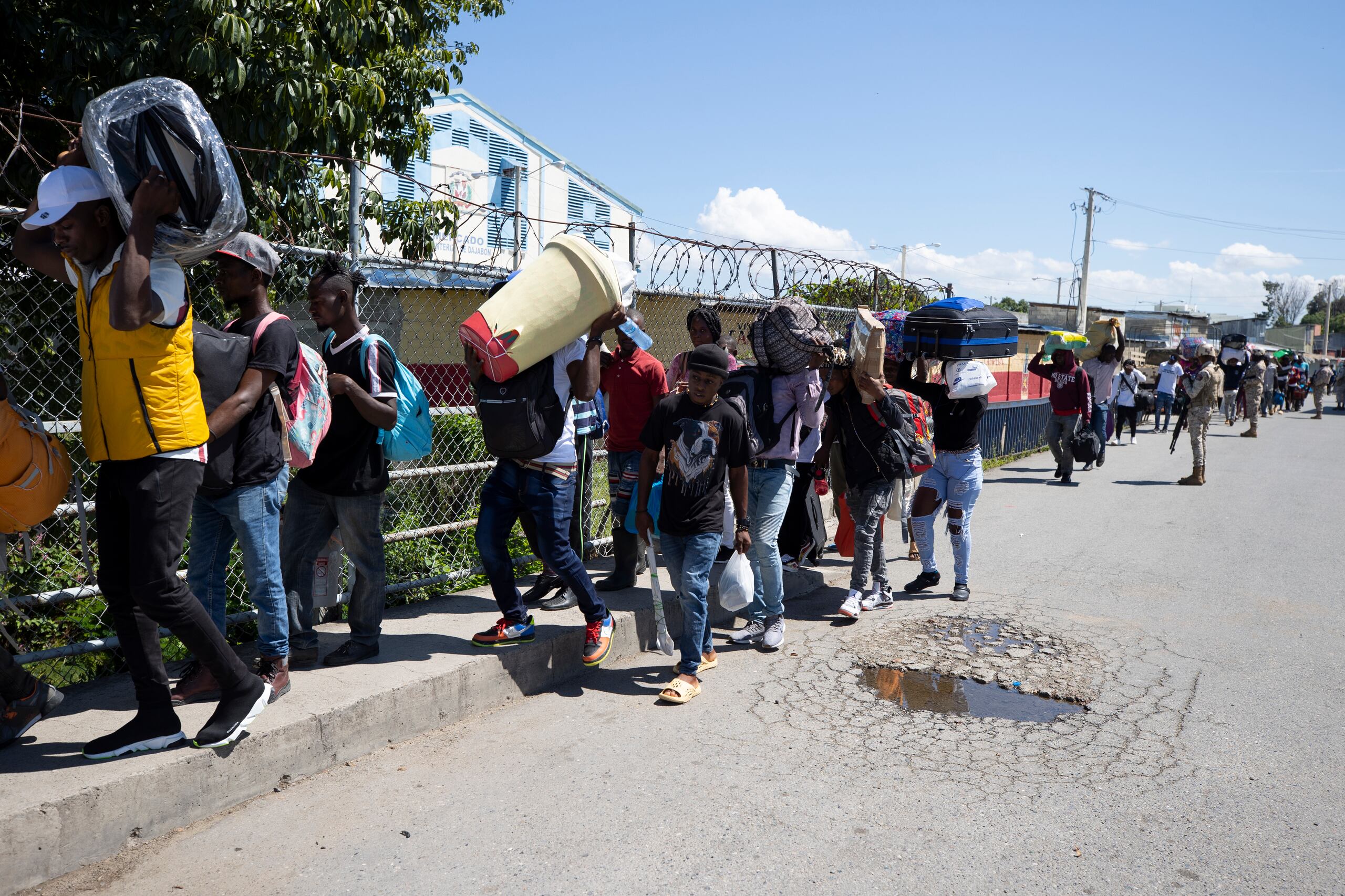 Haitianos vigilados por miembros del Cuerpo Especializado en Seguridad Fronteriza Terrestre de República Dominicana abandonan el país en un éxodo de miles de personas debido a un conflicto hídrico, hoy en Dajabón (República Dominicana).