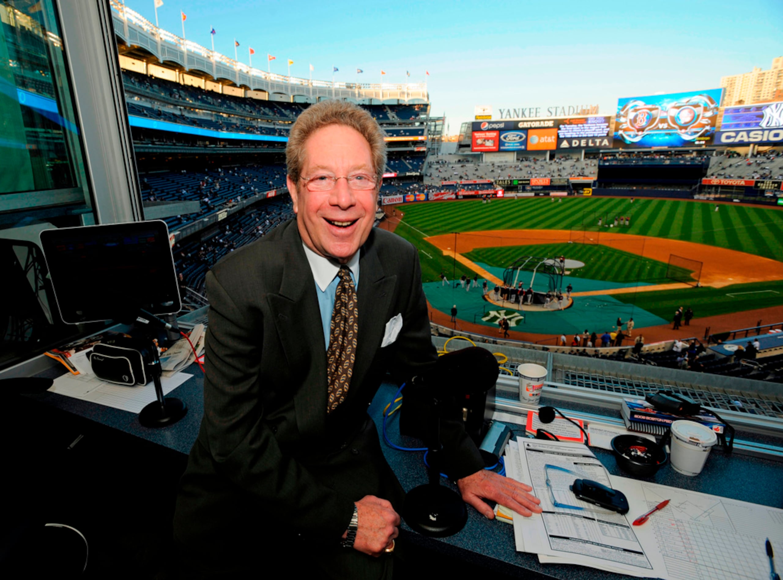 ARCHIVO - En esta foto del 25 de septiembre de 2009, John Sterling, locutor de los Yankees de Nueva York, posa en la cabina de transmisión previo a un juego contra los Red Sox de Boston, en el Yankee Stadium. (AP Foto/Bill Kostroun)