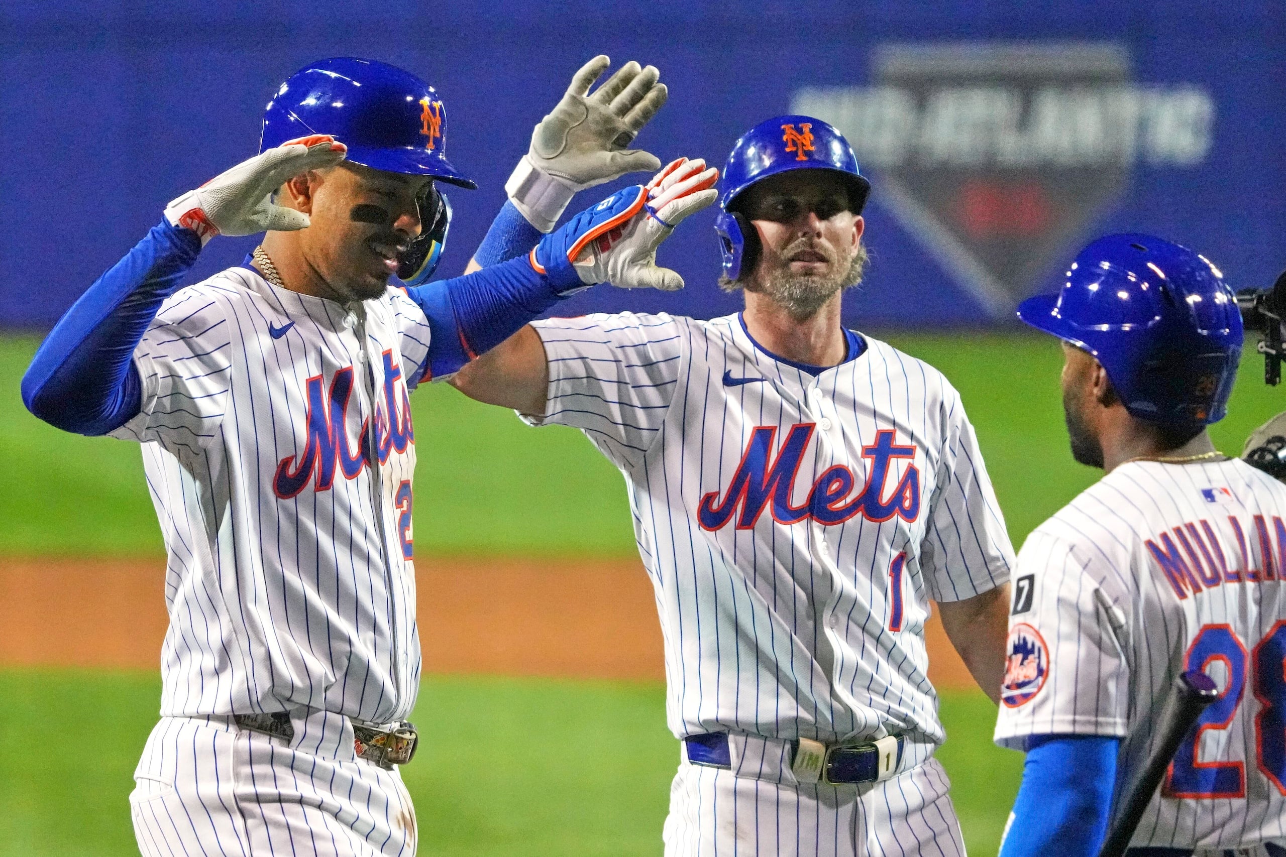 Mark Vientos, izquierda, de los Mets de Nueva York, es felicitado por Jeff McNeil (1), y Cedric Mullins (28) mientras regresa al dugout después de batear un jonrón de tres carreras frente a George Kirby, de los Marineros de Seattle en el partido de béisbol de Grandes Ligas en el Clásico de Pequeñas Ligas el domingo 17 de agosto de 2025 en Bowman Field en Williamsport, Penssylvania. (AP Foto/Gene J. Puskar)
