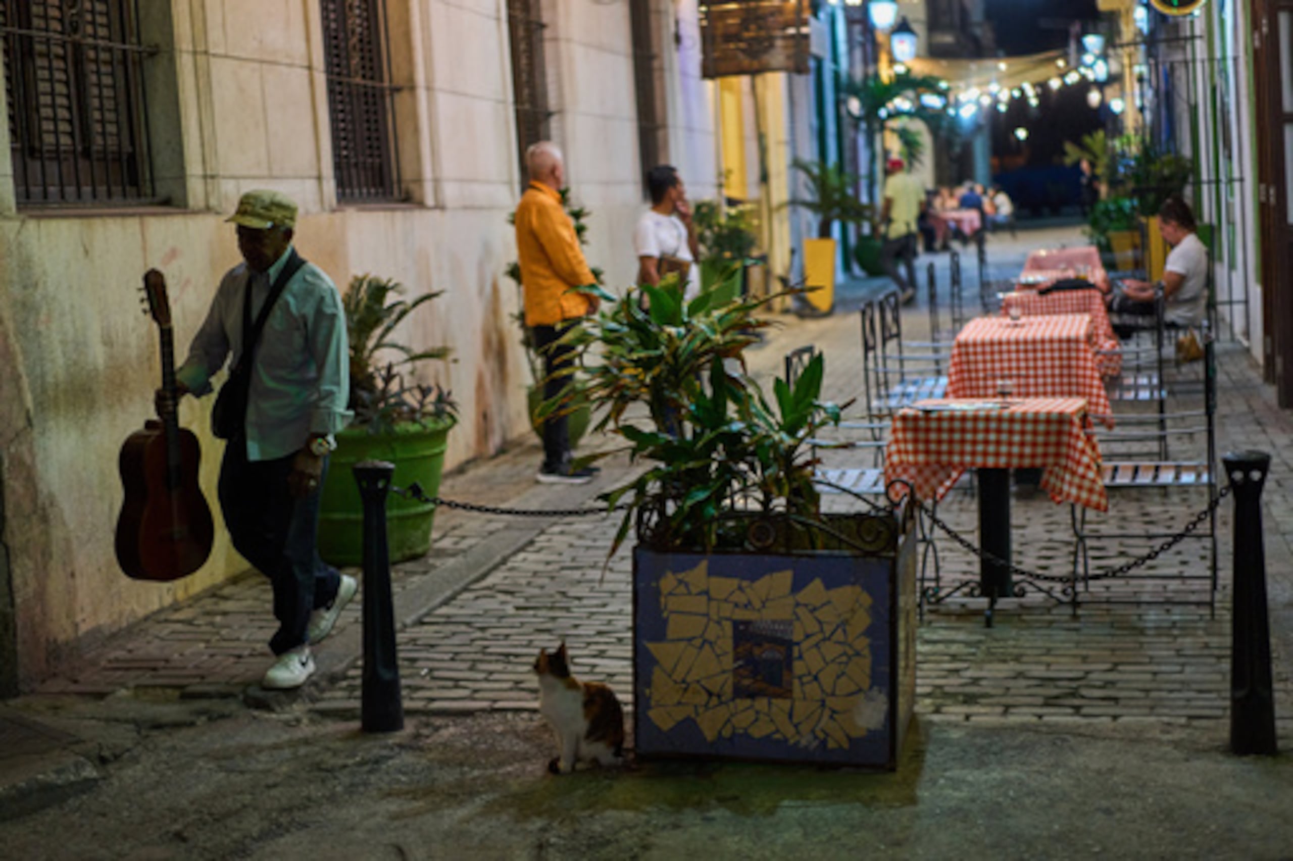 Un músico callejero pasa por delante de un restaurante en La Habana, miércoles 15 de abril de 2026. (AP Photo/Ramon Espinosa)