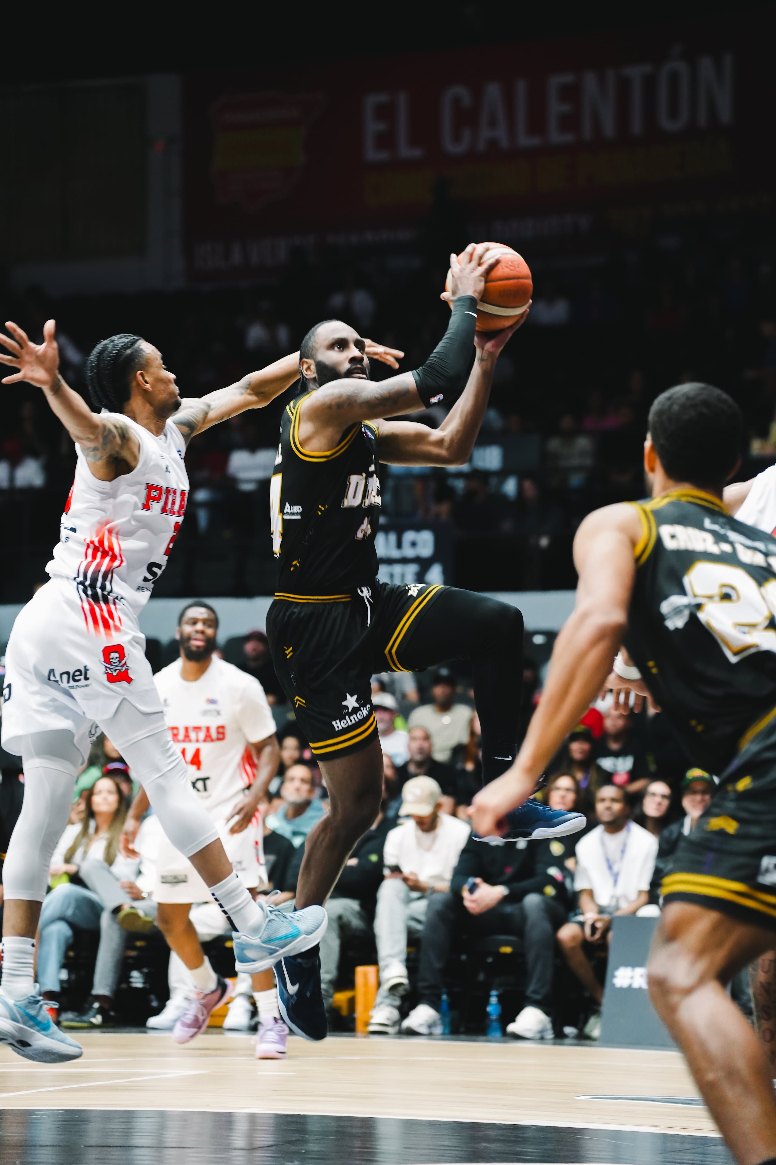 Jaylen Nowell, refuerzo de los Gigantes de Carolina-Canóvanas, ataca el canasto ante la defensa de Víctor Liz, de los Piratas de Quebradillas.