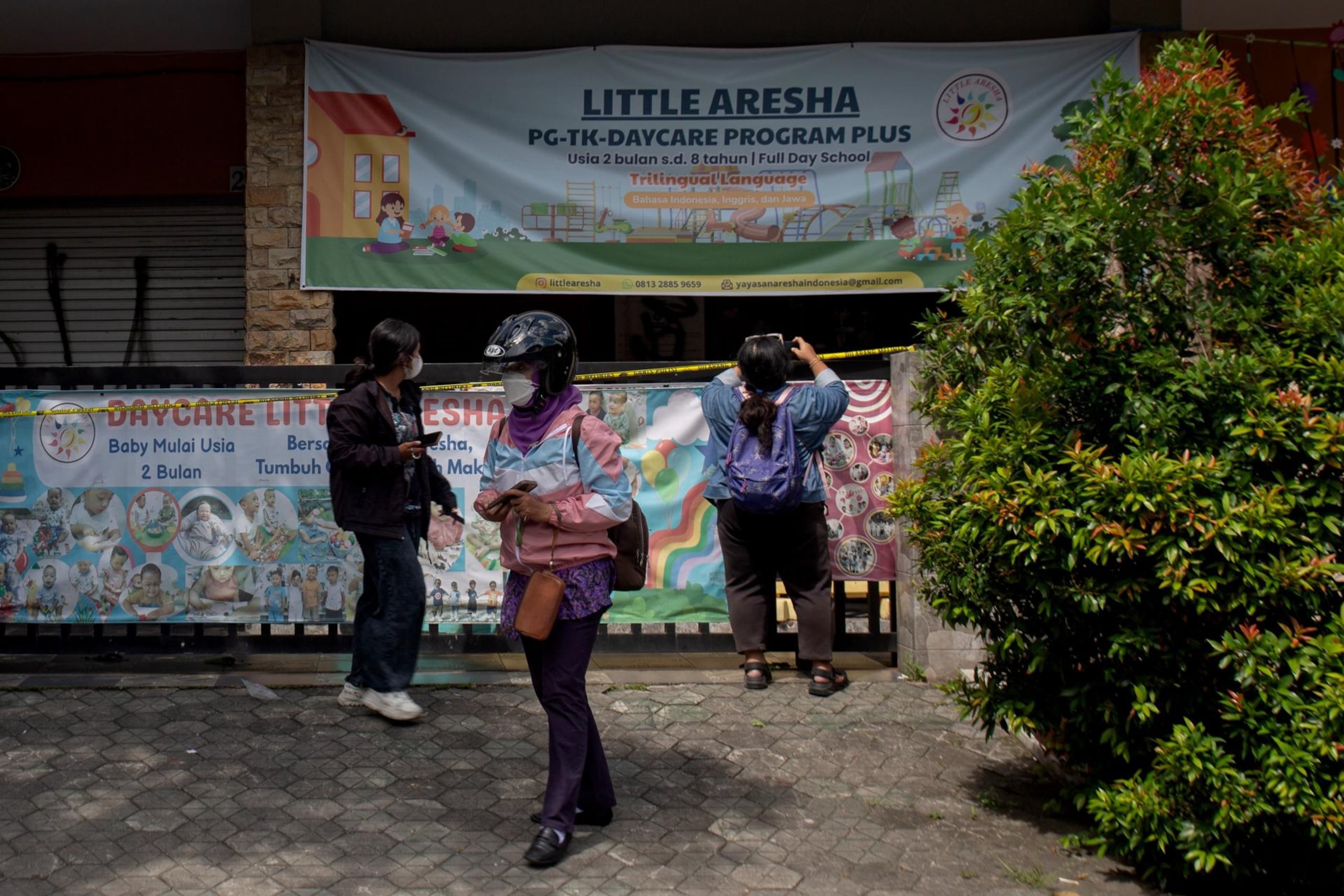 Personas toman fotografías del centro de cuidado infantil Little Aresha, que permanece cerrado, en Yogyakarta, Indonesia, el 28 de abril de 2026.