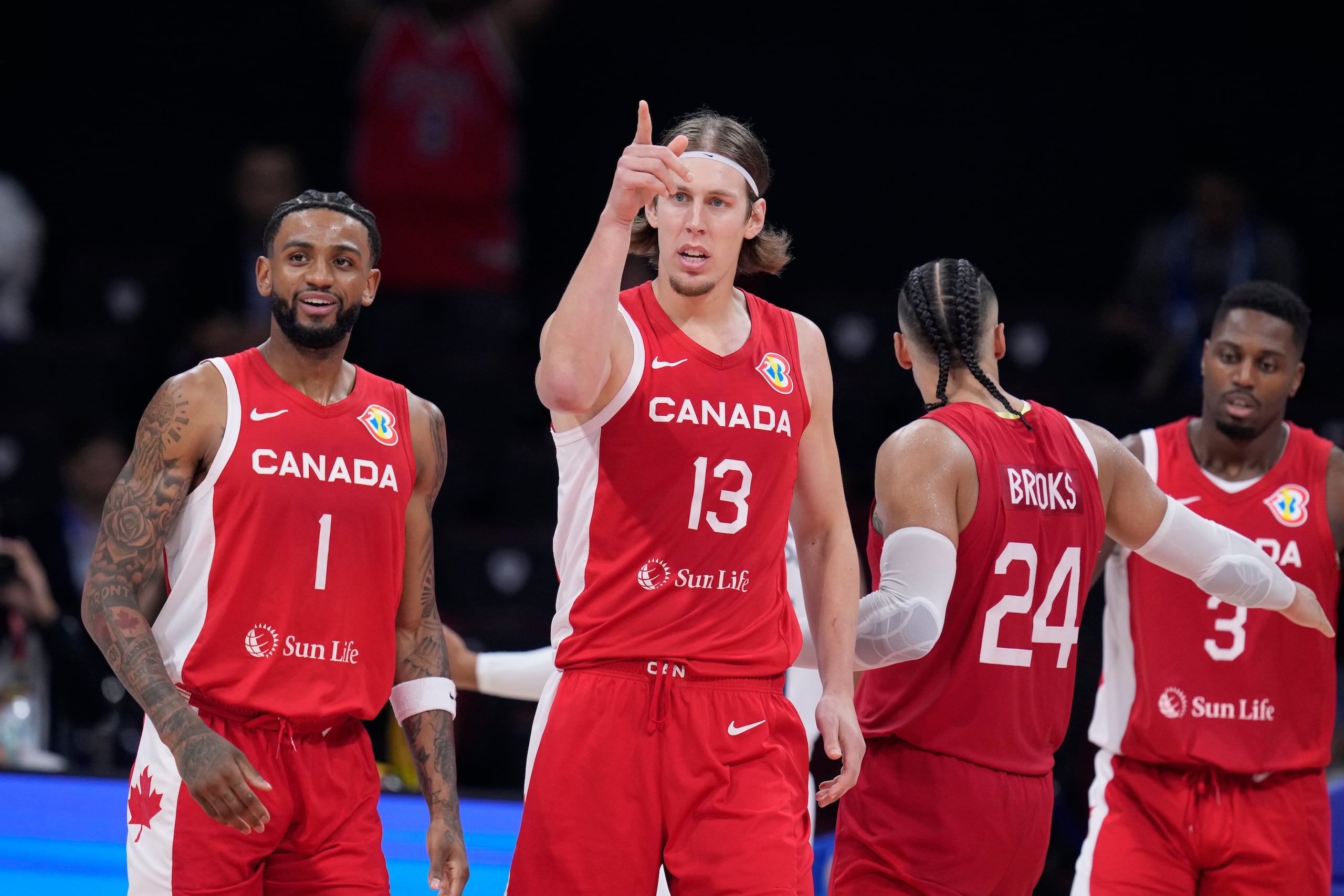 El delantero de Canadá, Kelly Olynyk (13), hace una señal celebrando un canasto. Los canadienses han vencido a Estados Unidos por apenas segunda ocasión en 23 juegos históricos de la FIBA. Y el bronce es su primera medalla en un Mundial en 87 años.