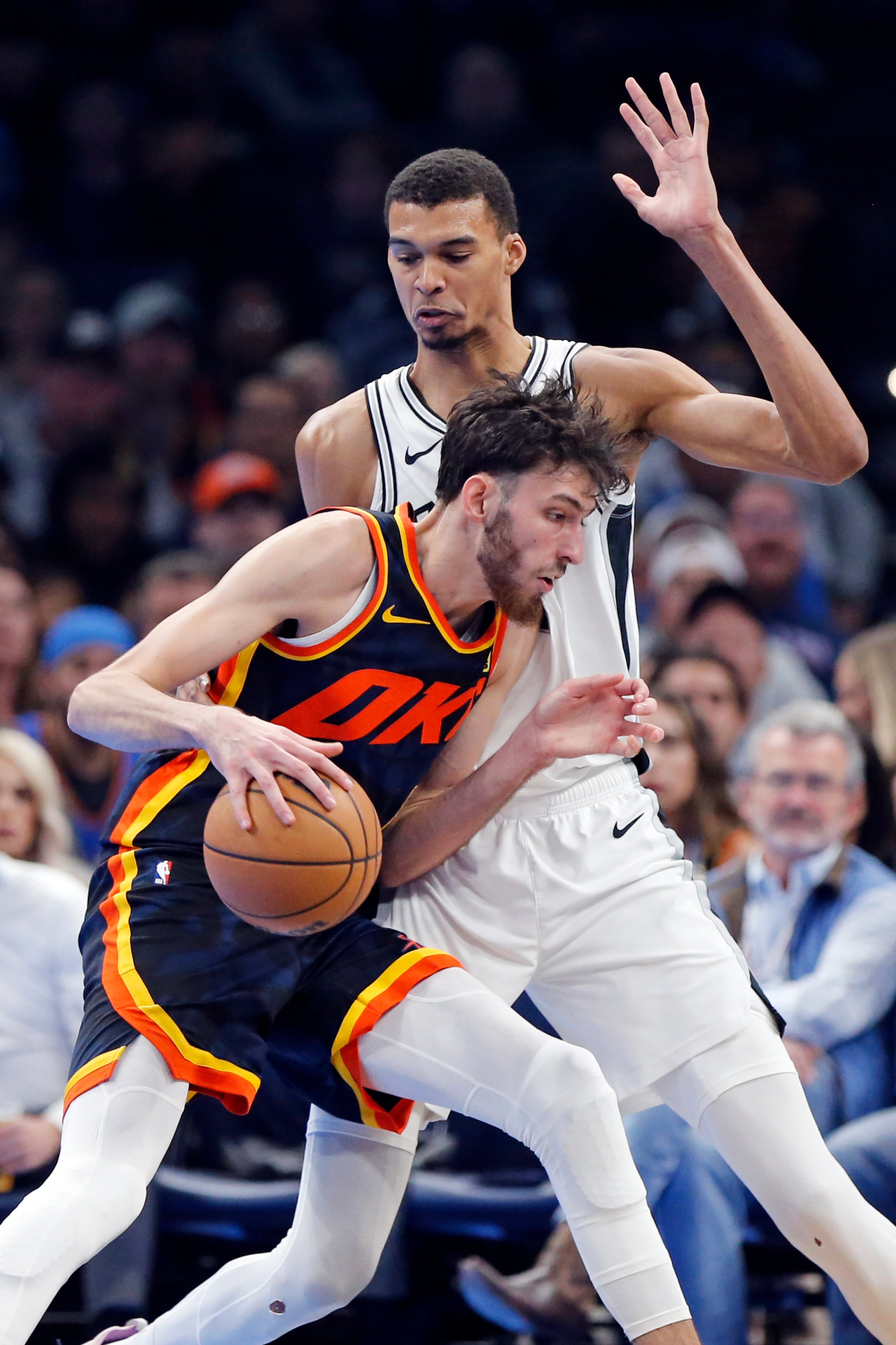 Chet Holmgren, del Thunder de Oklahoma, controla el balón ante la defensa de Victor Wembanyama, de los Spurs de San Antonio.