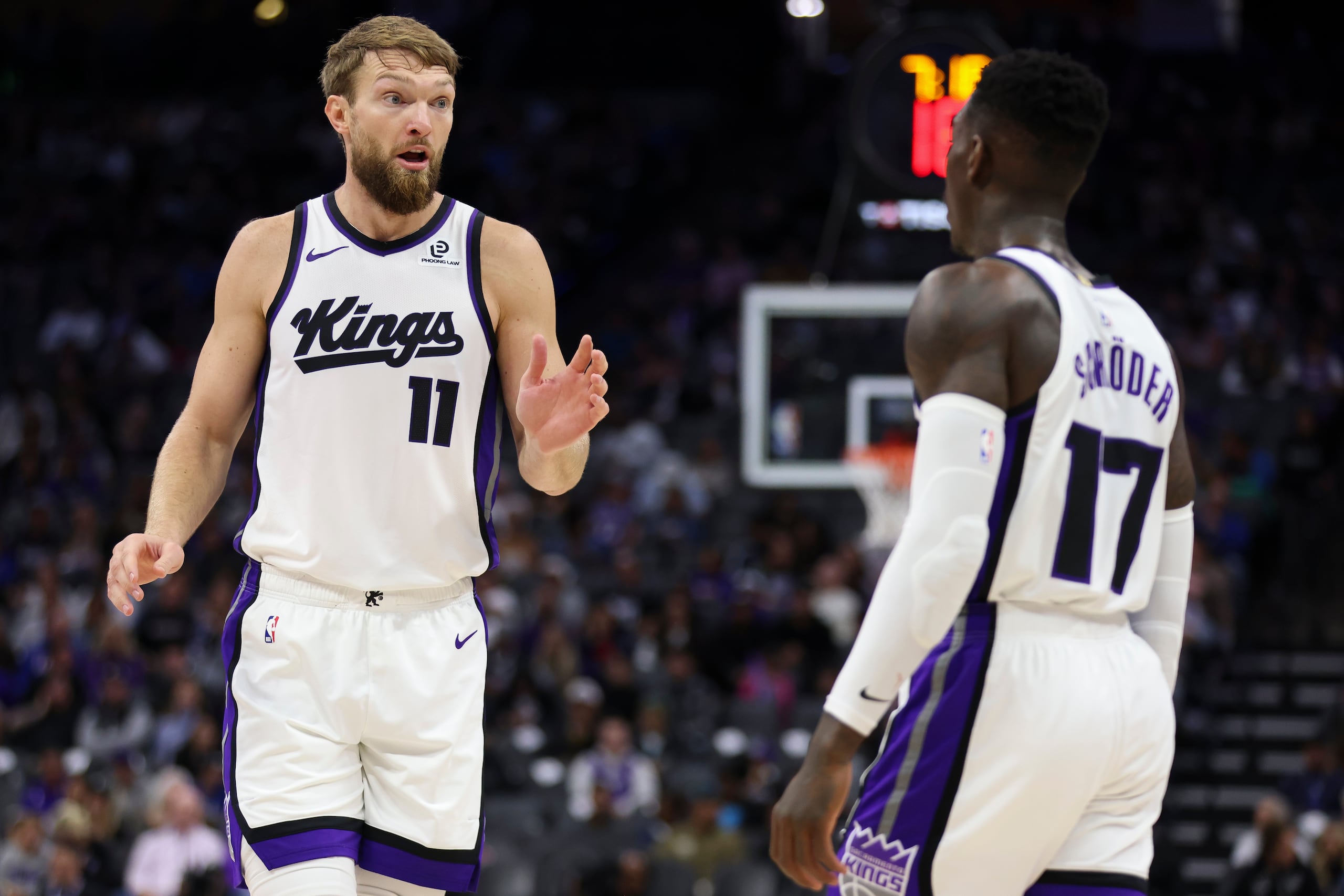 Domantas Sabonis (11) y Dennis Schröder (17) de los Kings de Sacramento conversan durante la primera mitad de un partido de pretemporada de la NBA contra los Clippers de Los Ángeles, el miércoles 15 de octubre de 2025, en Sacramento, California. (AP Photo/Scott Marshall)