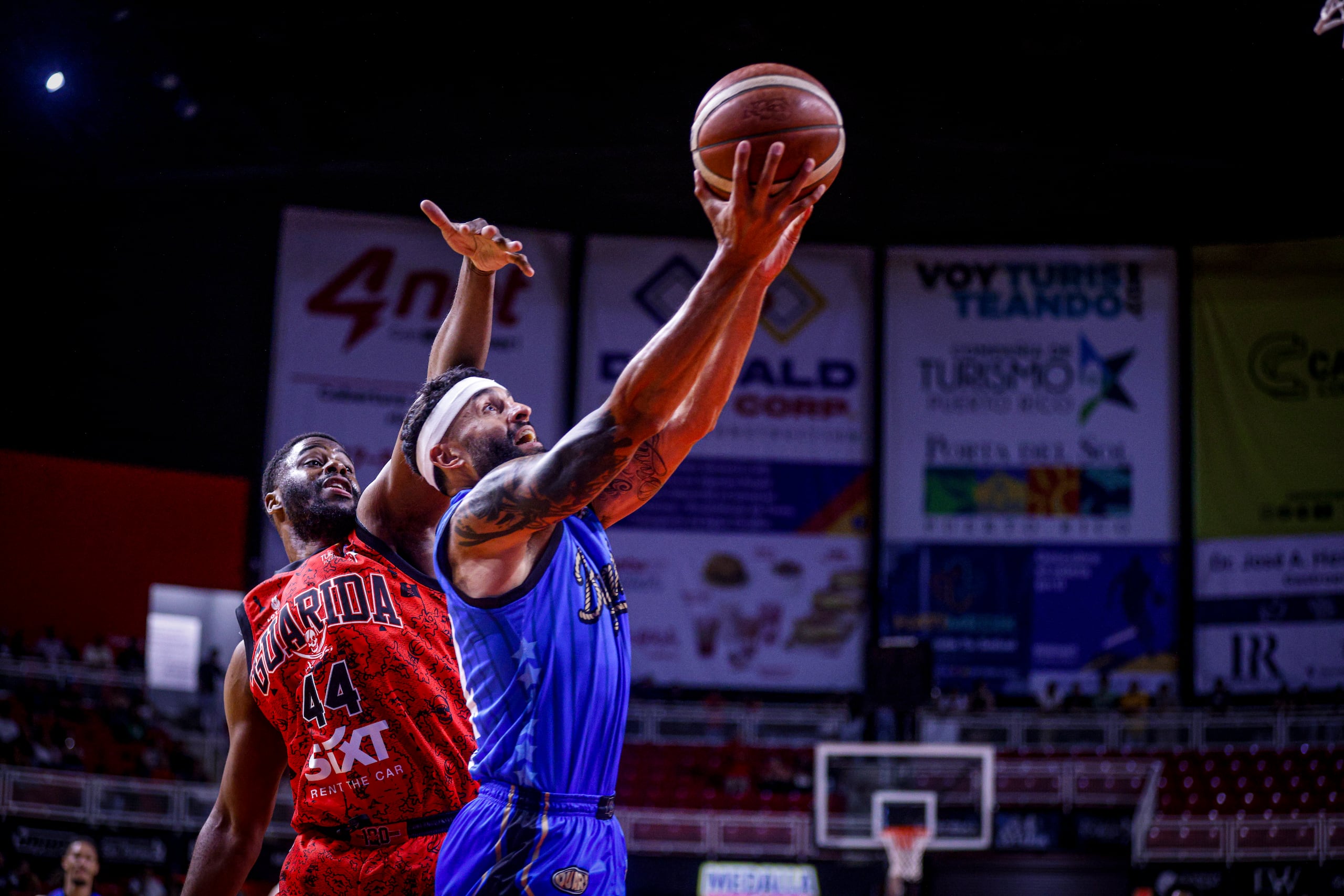 Javier Mojica ataca el canasto tras superar a Emmanuel Mudiay en un juego entre los Vaqueros de Bayamón y los Piratas de Quebradillas.