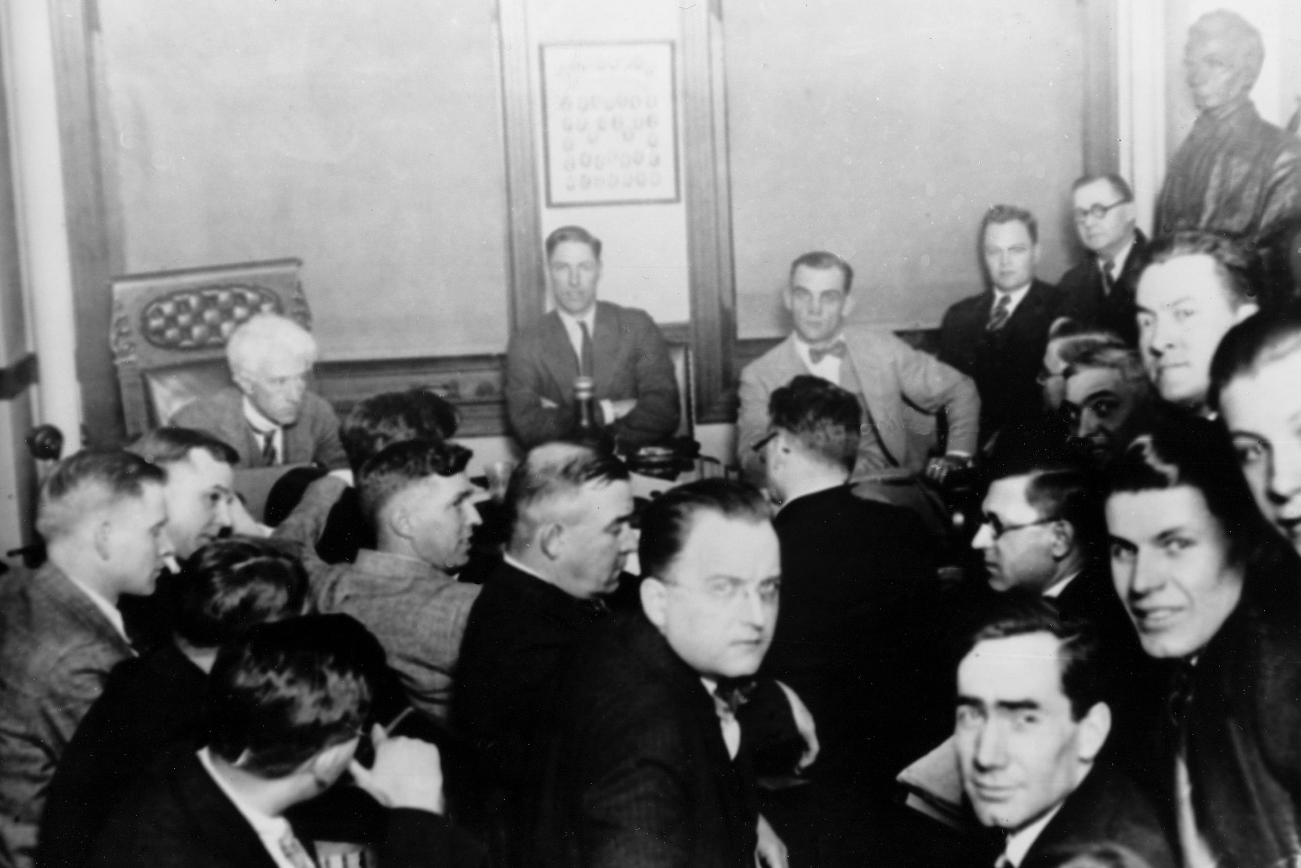 En esta foto del 1921, aparece el juez Kenesaw Mountain Landis, a la parte izquierda posterior, mientras los jugadores de los Chicago White Sox "Swede" Risberg, al centro, y Arnold "Chick" Gandil, observan mientras investigan al equipo por amañar la Serie Mundial.