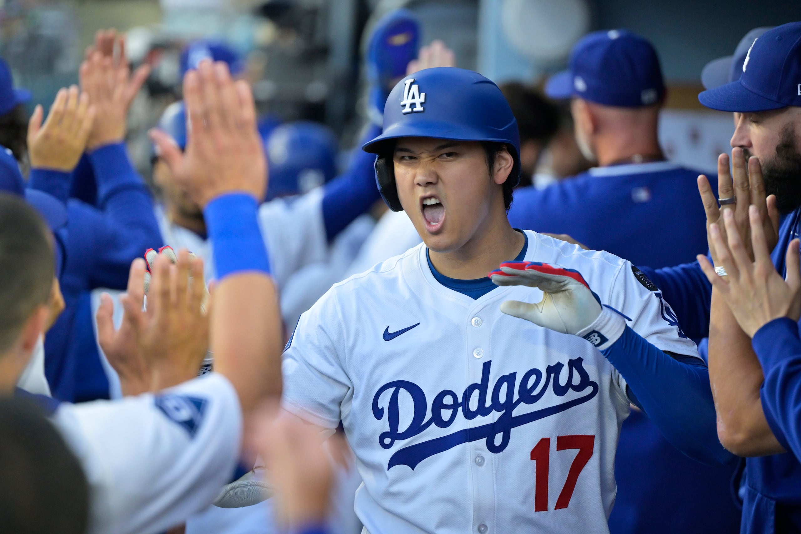 Shohei Ohtani (17), de los Dodgers de Los Ángeles, es felicitado por sus compañeros de equipo después de batear un cuadrangular de dos carreras contra los Mellizos de Minnesota durante la primera entrada del juego de béisbol de Grandes Ligas el lunes 21 de julio de 2025. (AP Photo/Jayne Kamin-Oncea)