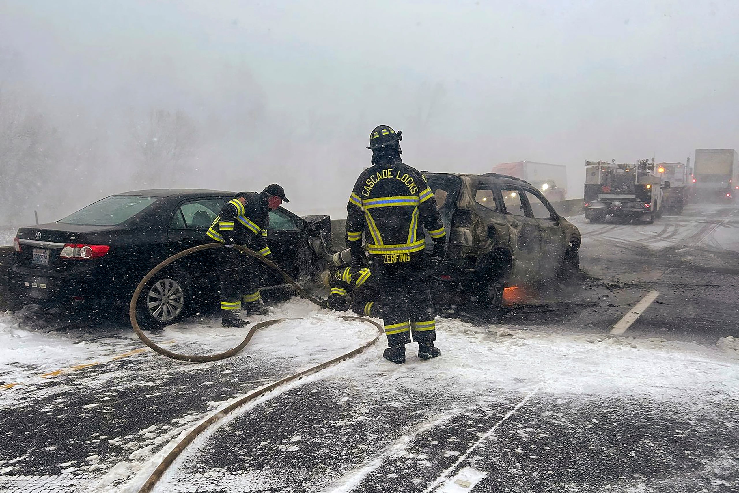 En esta fotografía proporcionada por la policía del condado Multnomah, bomberos controlan el fuego de un vehículo que se incendió en la carretera interestatal 84, el jueves 13 de febrero de 2025, cerca de las cataratas de Multnomah, Oregon. (Policía del condado Multnomah vía AP)