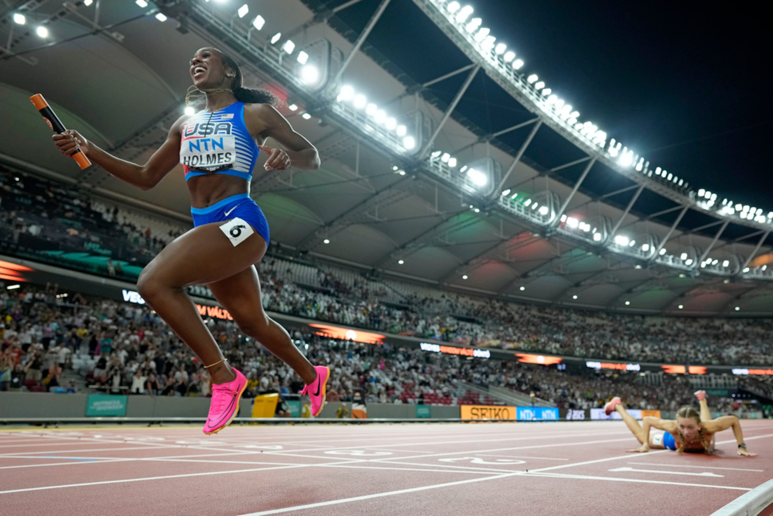 Alexis Holmes celebra después de asegurara la medalla de oro para Estados Unidos, mientras Femke Bol, de Holanda, permanece en en el suelo.
