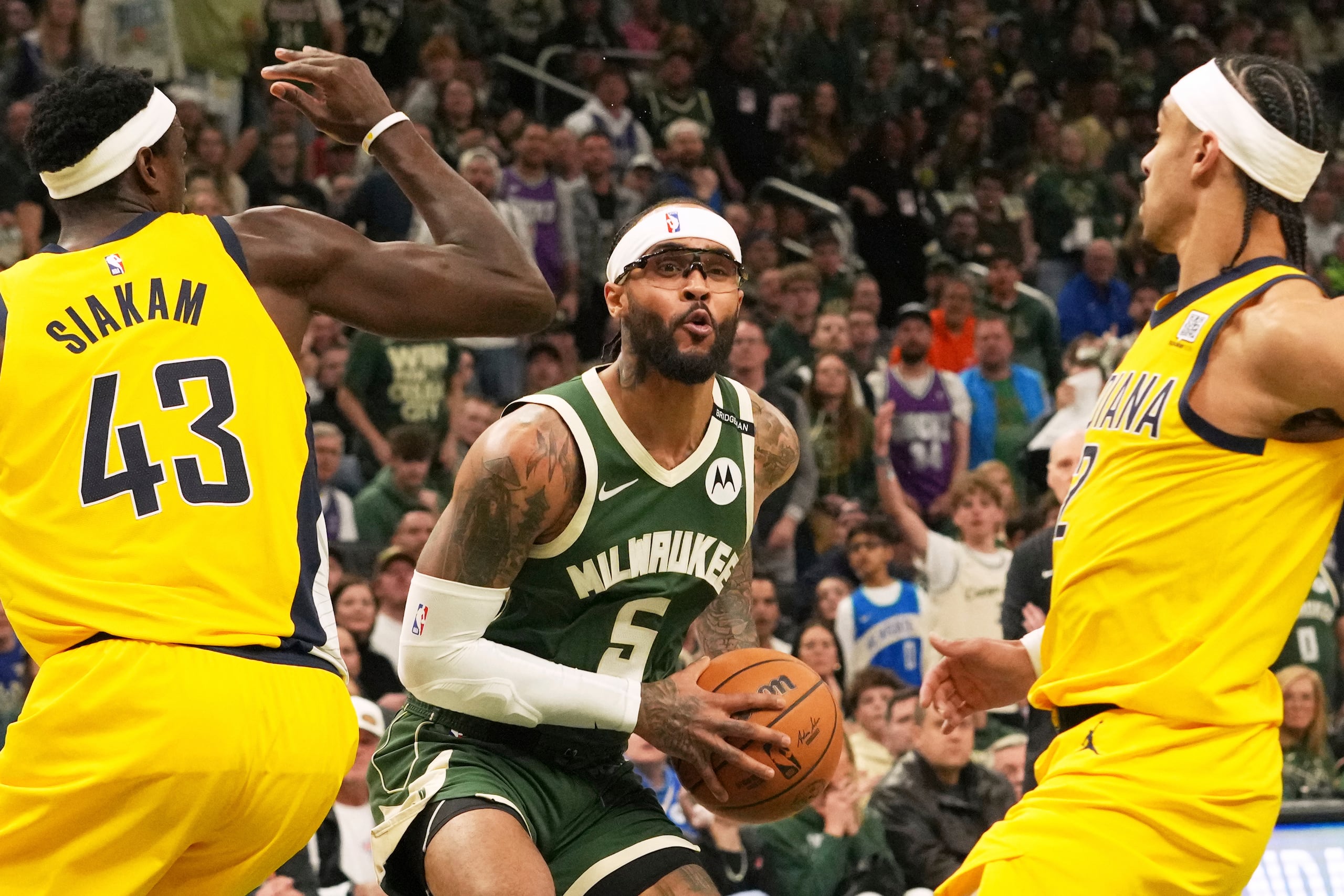 Milwaukee Bucks guard Gary Trent Jr., center, looks to pass the ball against Indiana Pacers forward Pascal Siakam, left, and guard Andrew Nembhard, right, during the first half in Game 3 of an NBA basketball first-round playoff series Friday, April 25, 2025, in Milwaukee. (AP Photo/Nam Y. Huh)