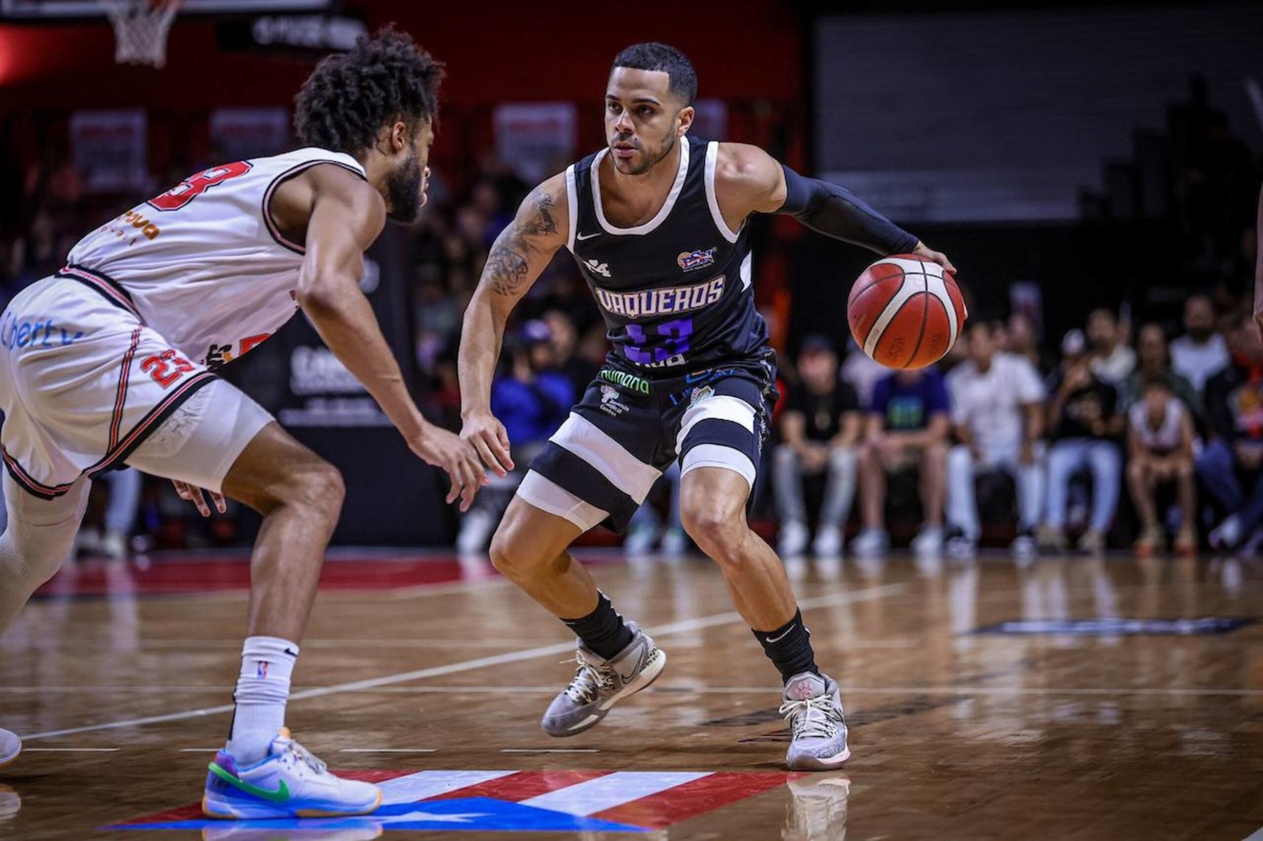 Ángel Rodríguez, armador de los Vaqueros, maneja el balón contra Phillip Wheeler, de los Piratas, durante la acción del partido del miércoles en la noche ganado por Bayamón. Si Piratas y Vaqueros finalizan la temporada regular empatados en marca de ganados y perdidos, los campeones Vaqueros ganarán la ventaja de cancha local en todos los playoffs porque le ganaron sus dos juegos de la campaña a los Piratas.