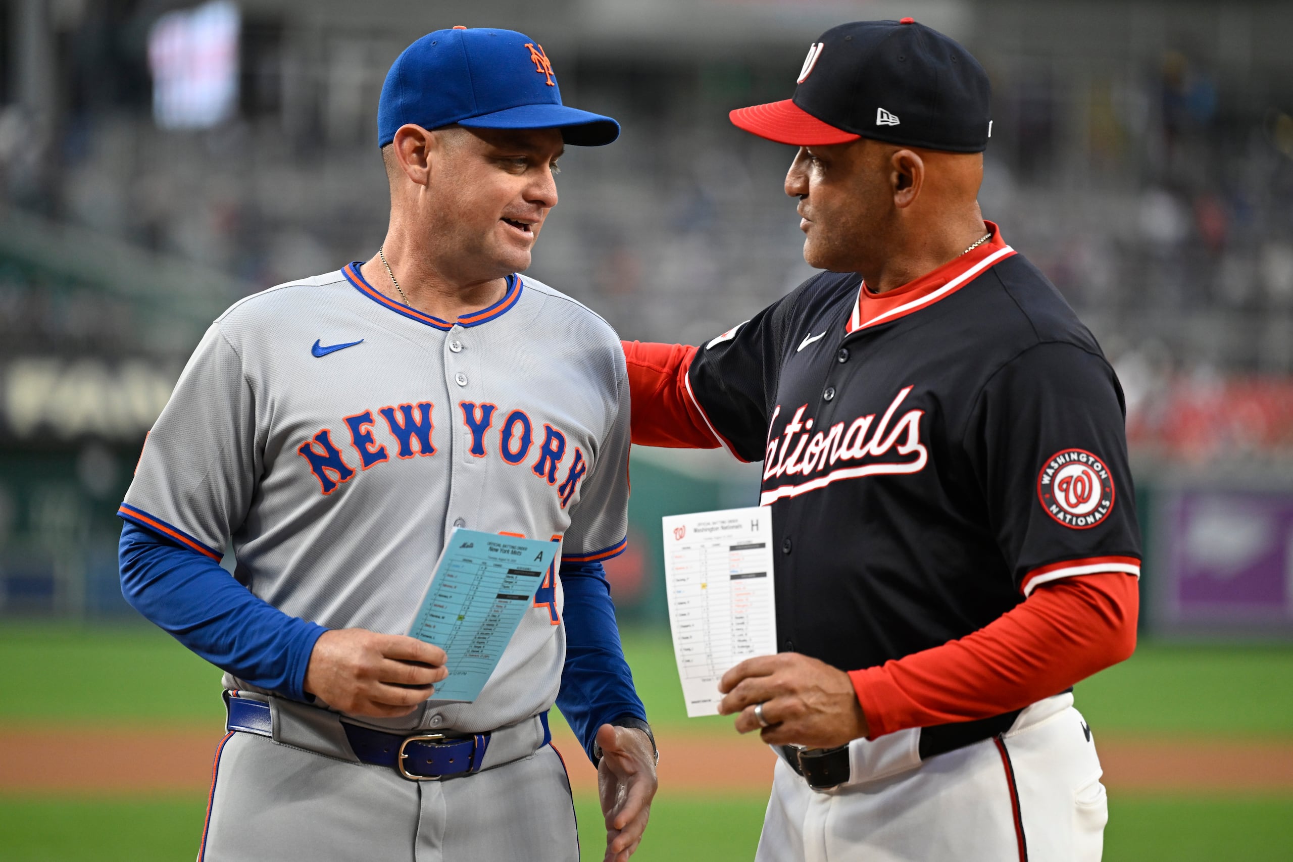 Carlos Mendoza, mánager de los Mets de Nueva York, y Miguel Cairo, su contraparte de los Nacionales de Washington, previo a un juego, el martes 19 de agosto de 2025, en Washington. (AP Foto/John McDonnell)