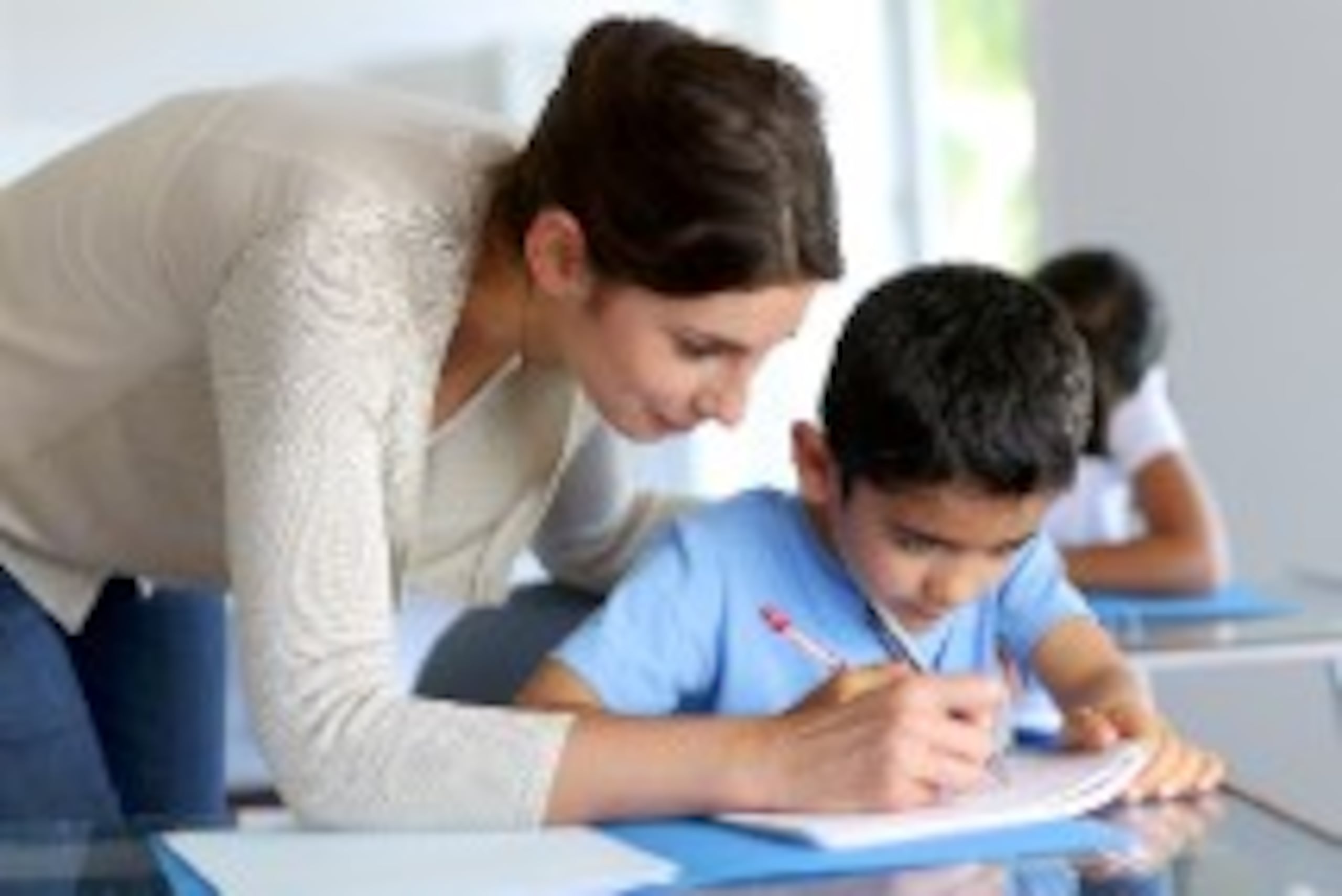 Un maestro de educación especial trabaja con una instrucción individualizada adaptada de acuerdo con las necesidades particulares del estudiante.