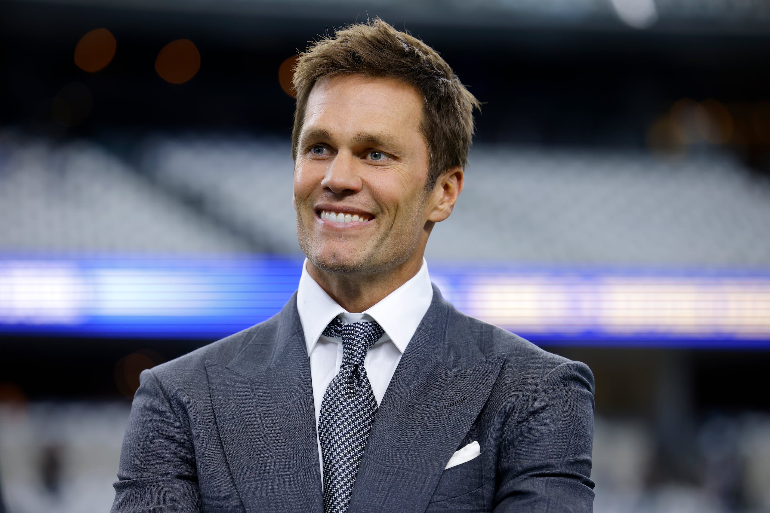 El analista principal de la NFL de Fox Sports, Tom Brady, se encuentra en el campo durante los calentamientos antes de un partido de fútbol americano de la NFL entre los Lions de Detroit y los Cowboys de Dallas en Arlington, Texas, el domingo 13 de octubre de 2024. (AP Foto/Gareth Patterson)