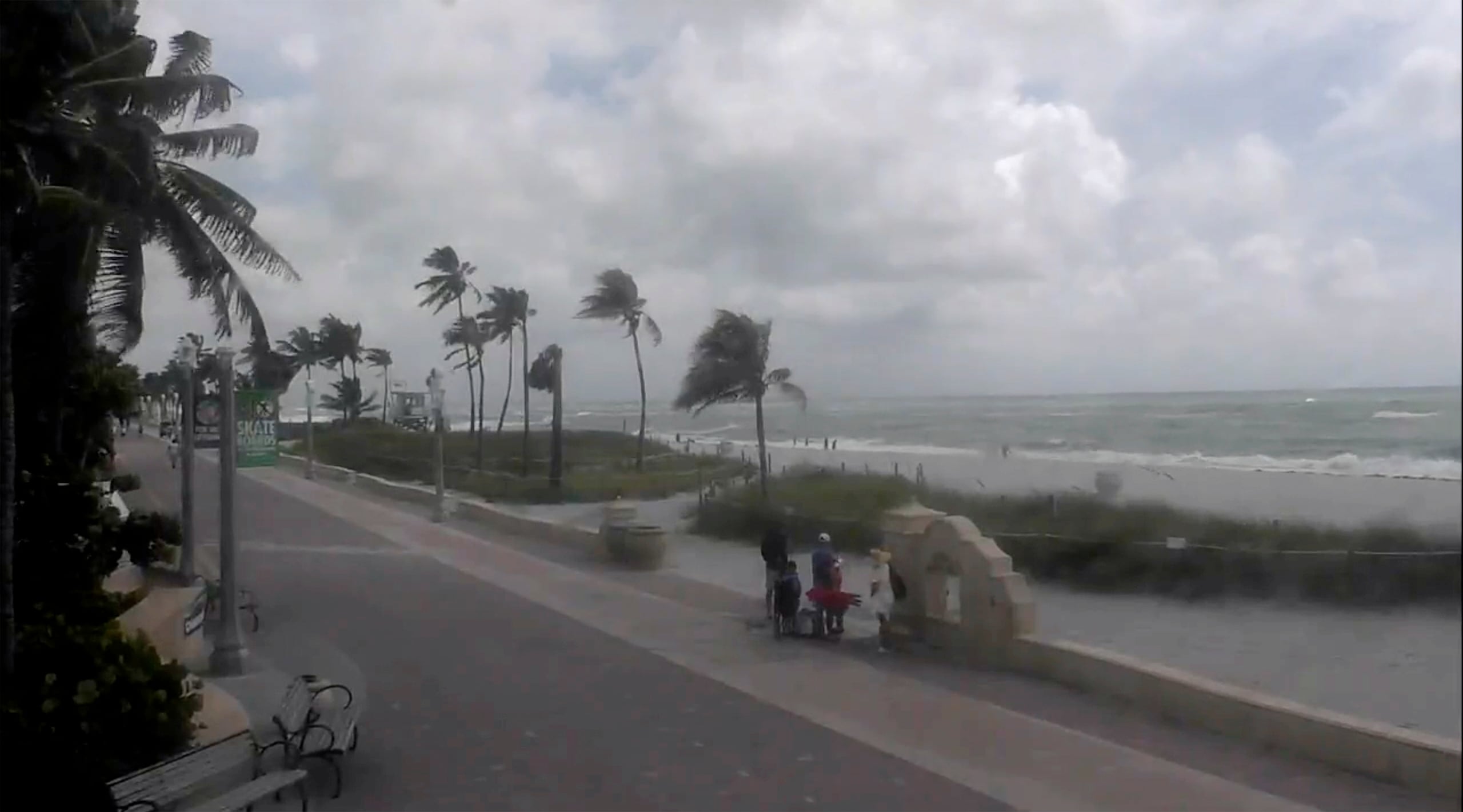 Varias personas caminan por una playa mientras la tormenta tropical Debby avanza por el Golfo de México hacia Florida el 4 de agosto de 2024, en Hollywood, Florida. (WPLG vía AP)