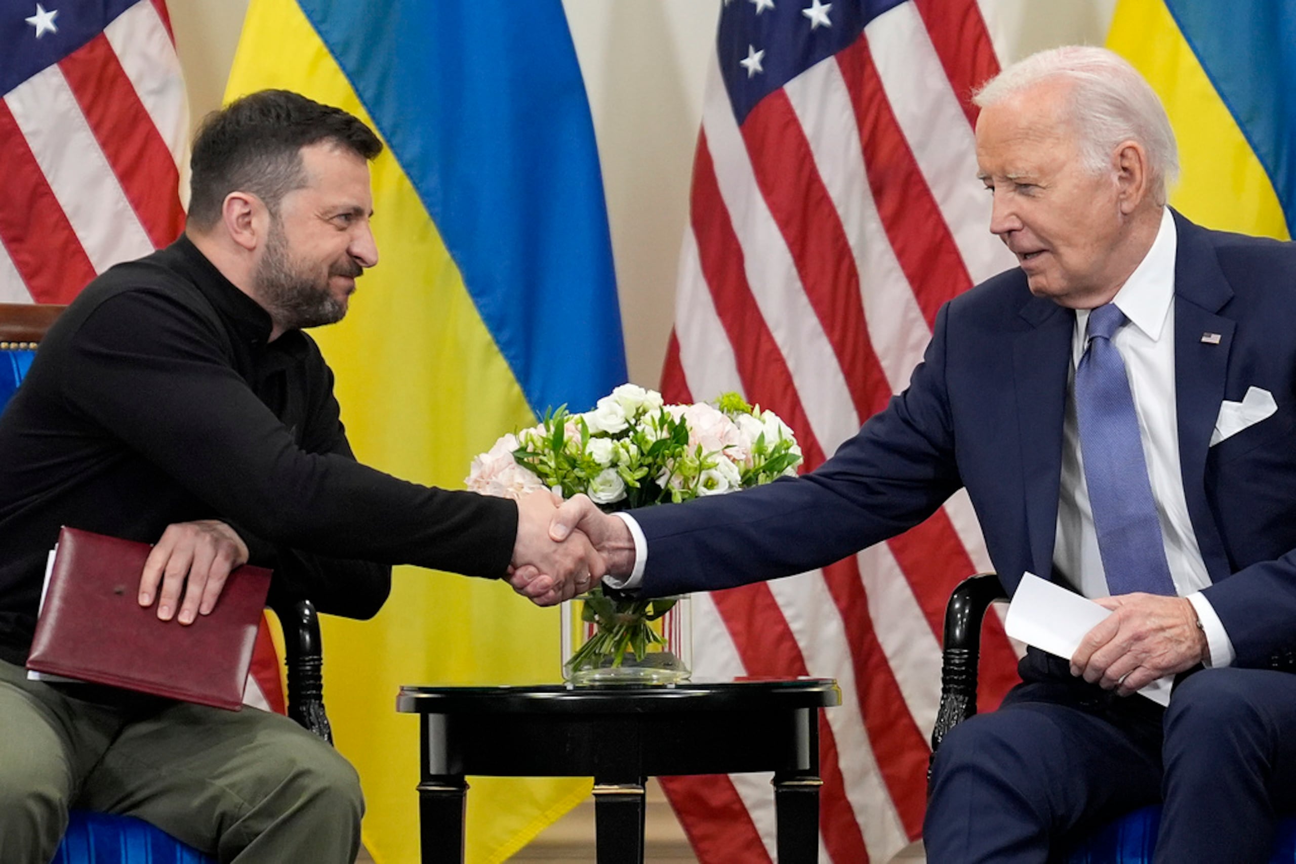 El presidente estadounidense Joe Biden le da la mano al presidente ucraniano Volodymyr Zelenskyy en París el 7 de junio de 2024.